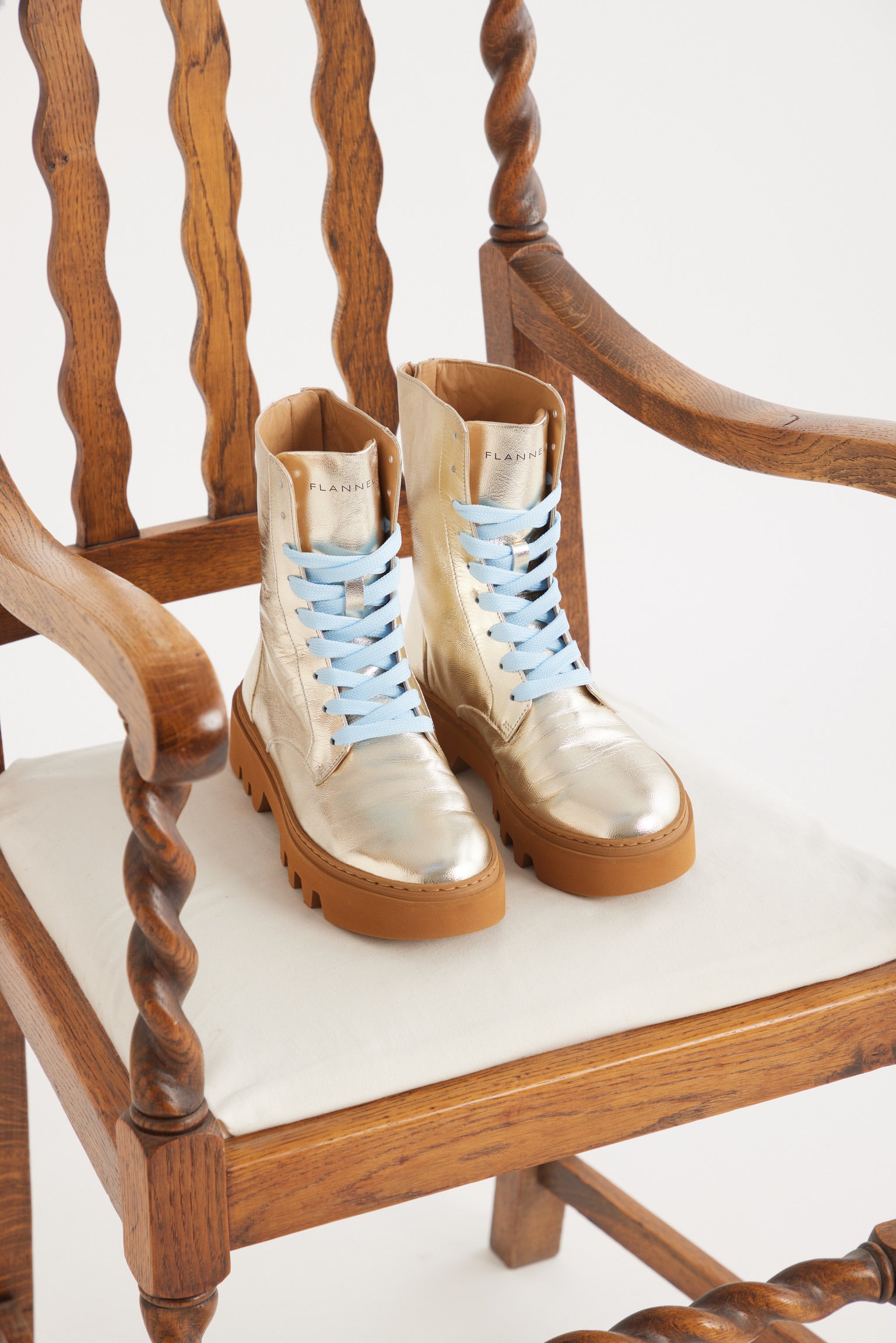 In situ image of gold boots sitting on a chair.