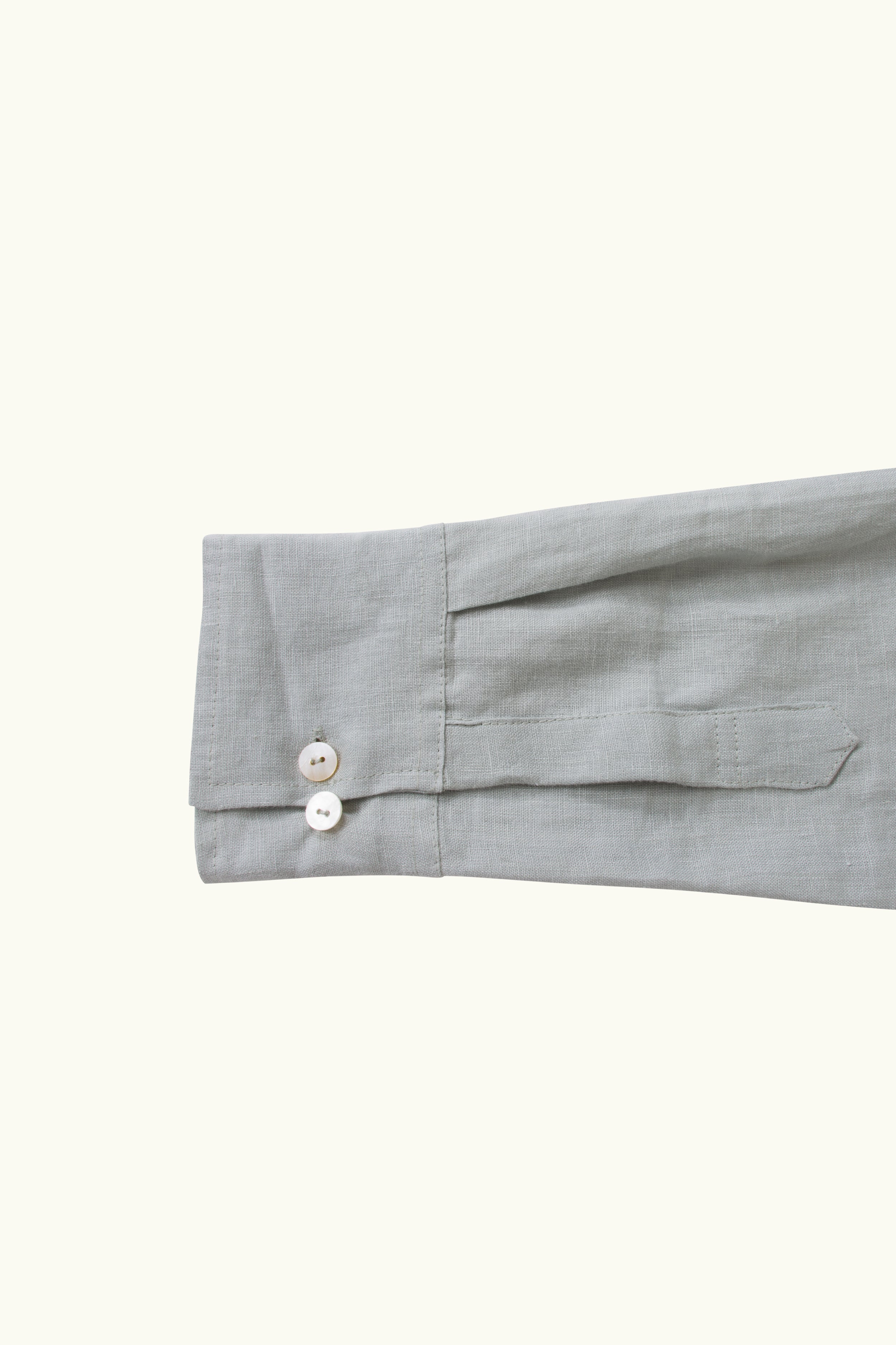 Close-up of a light blue sleeve with buttons on a white background