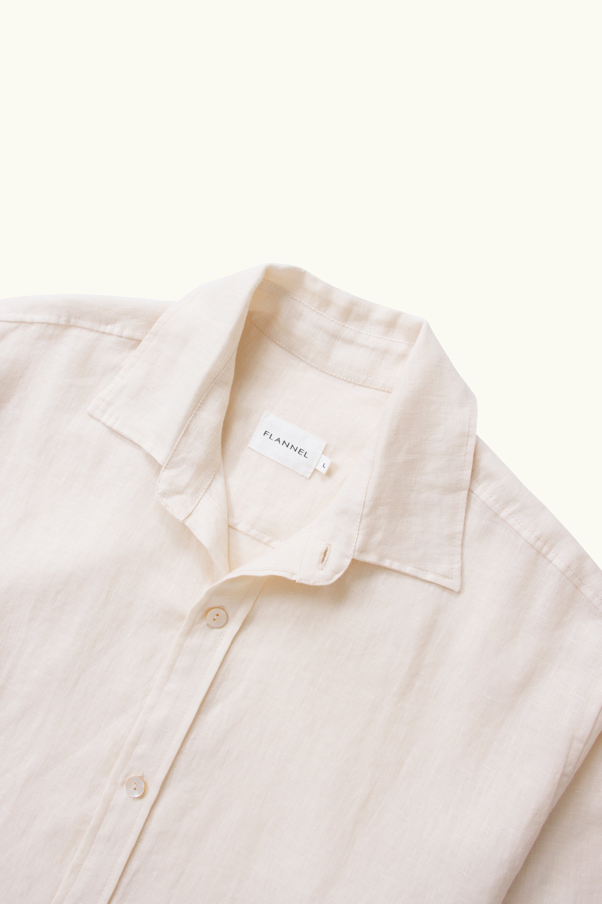 Close up of natural linen shirt collar and buttons on a white background