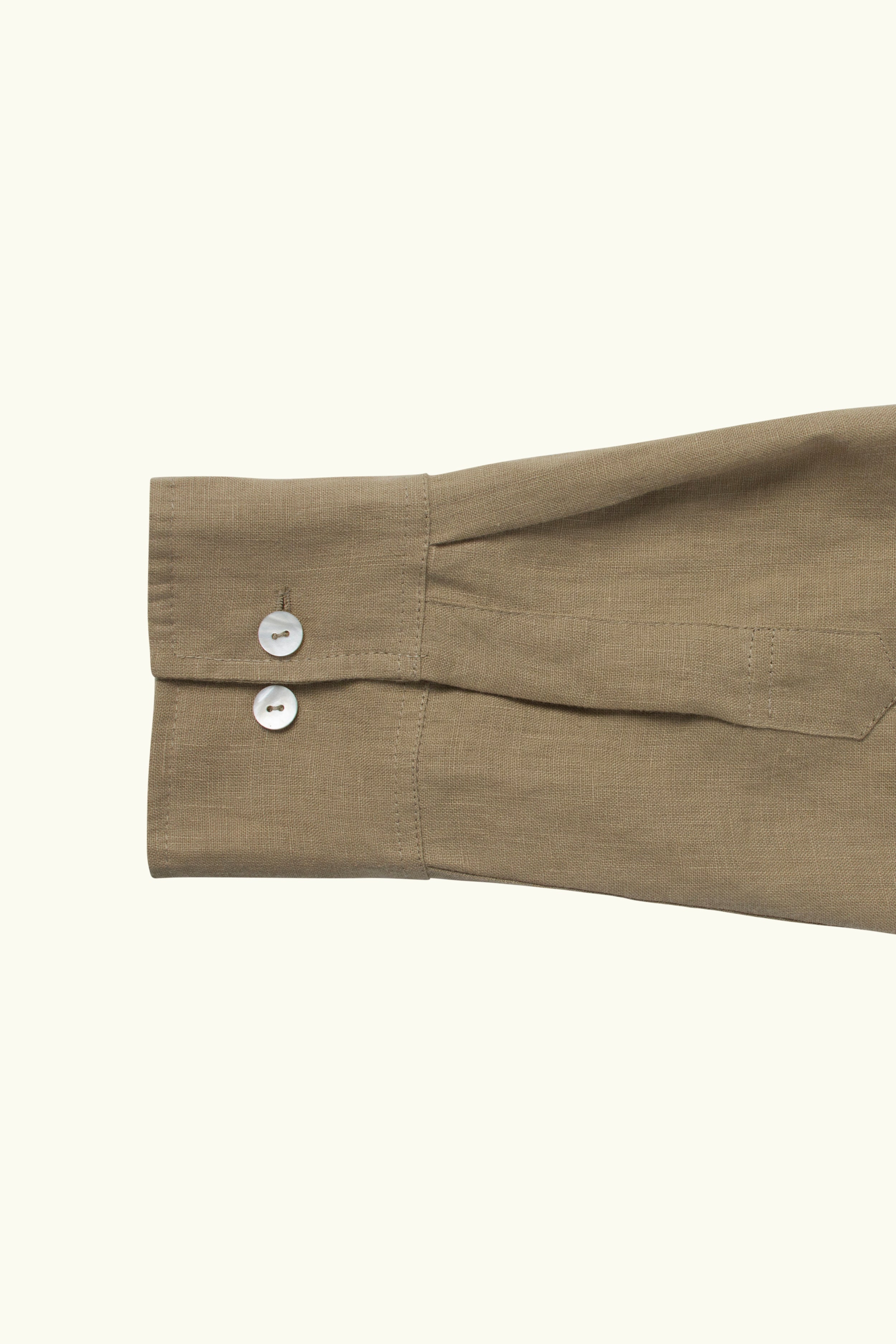 Close-up of a mocha shirt sleeve with buttons on a white background