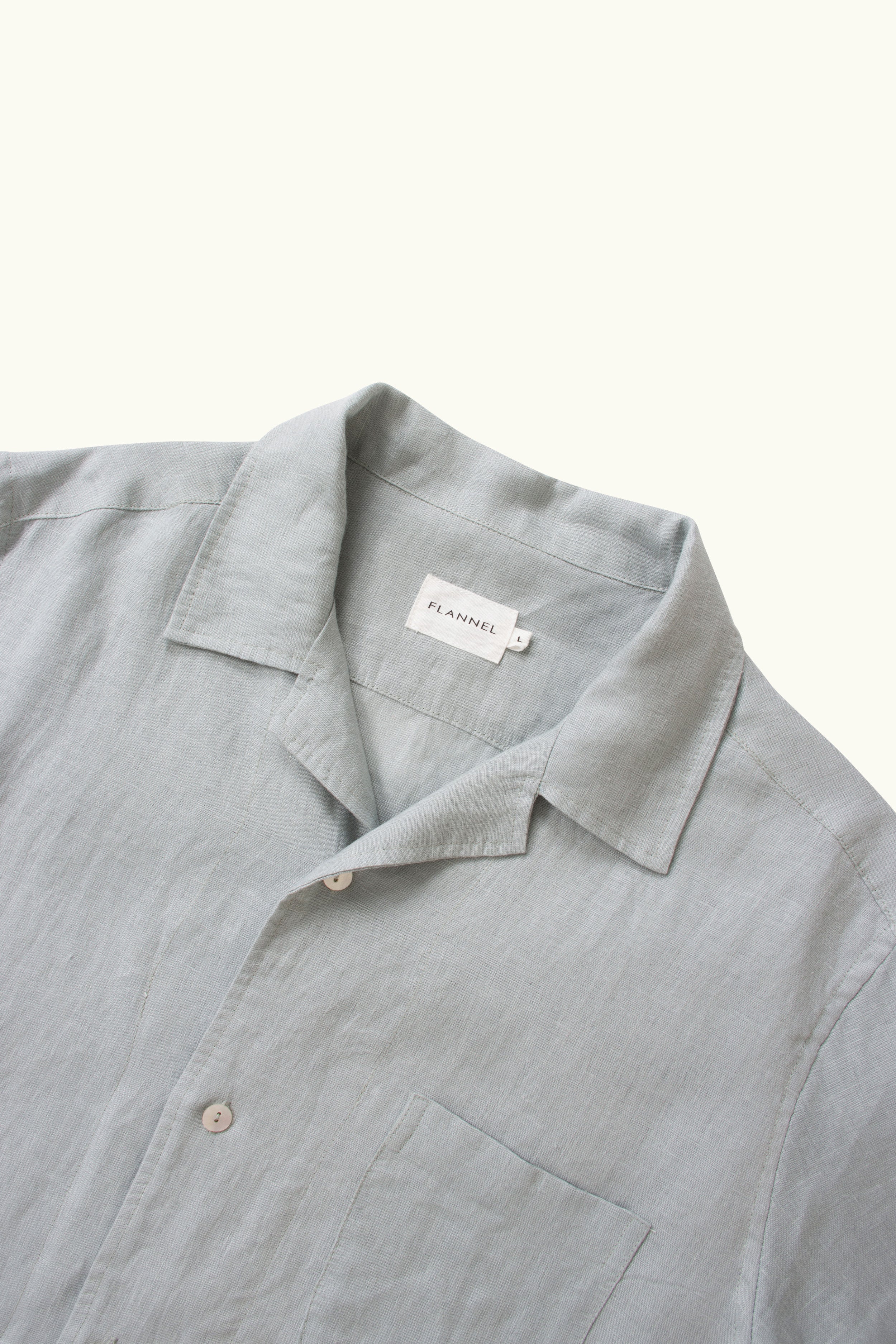 close up of the collar and buttons on a light blue linen shirt