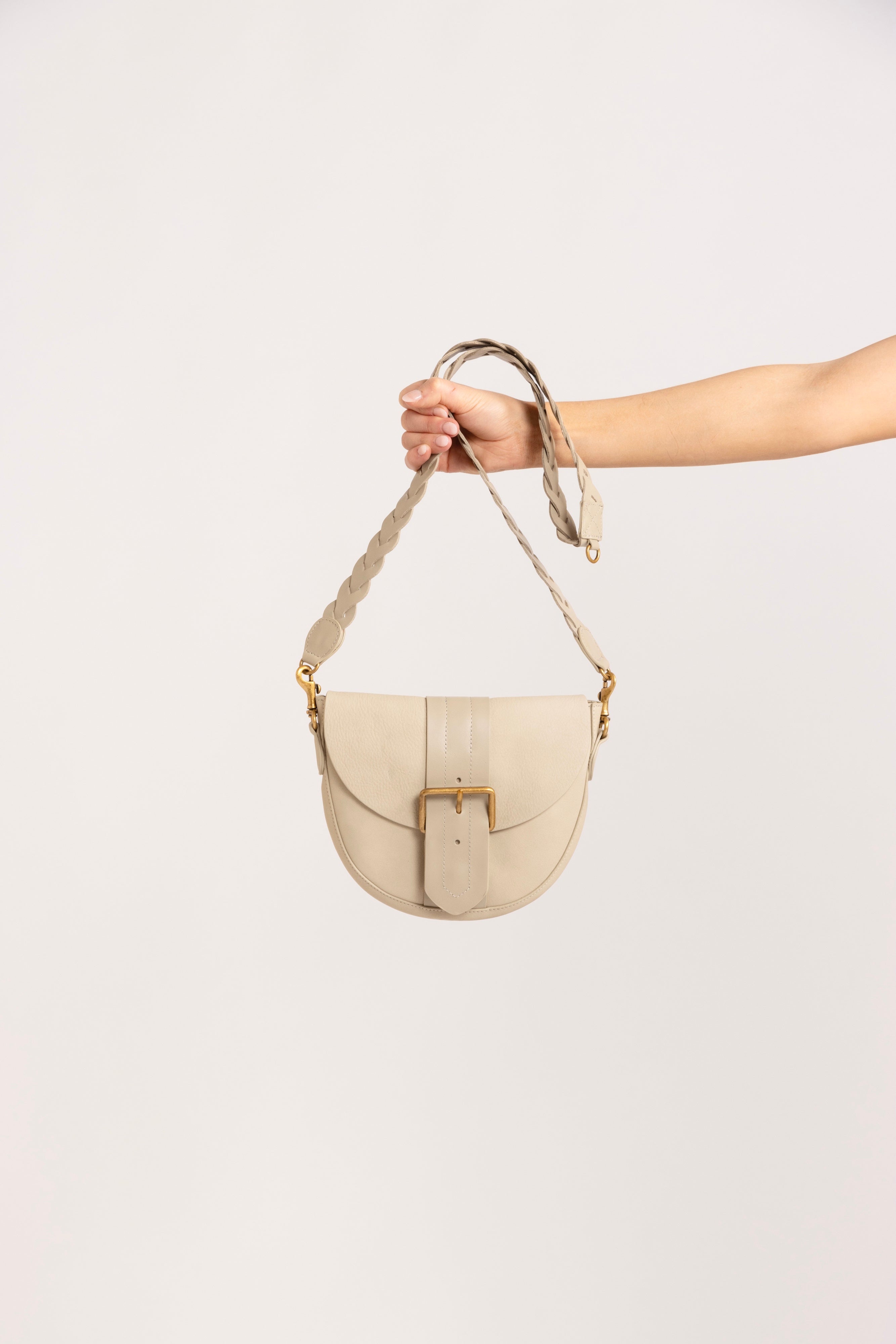Model holding a leather cream pouch.