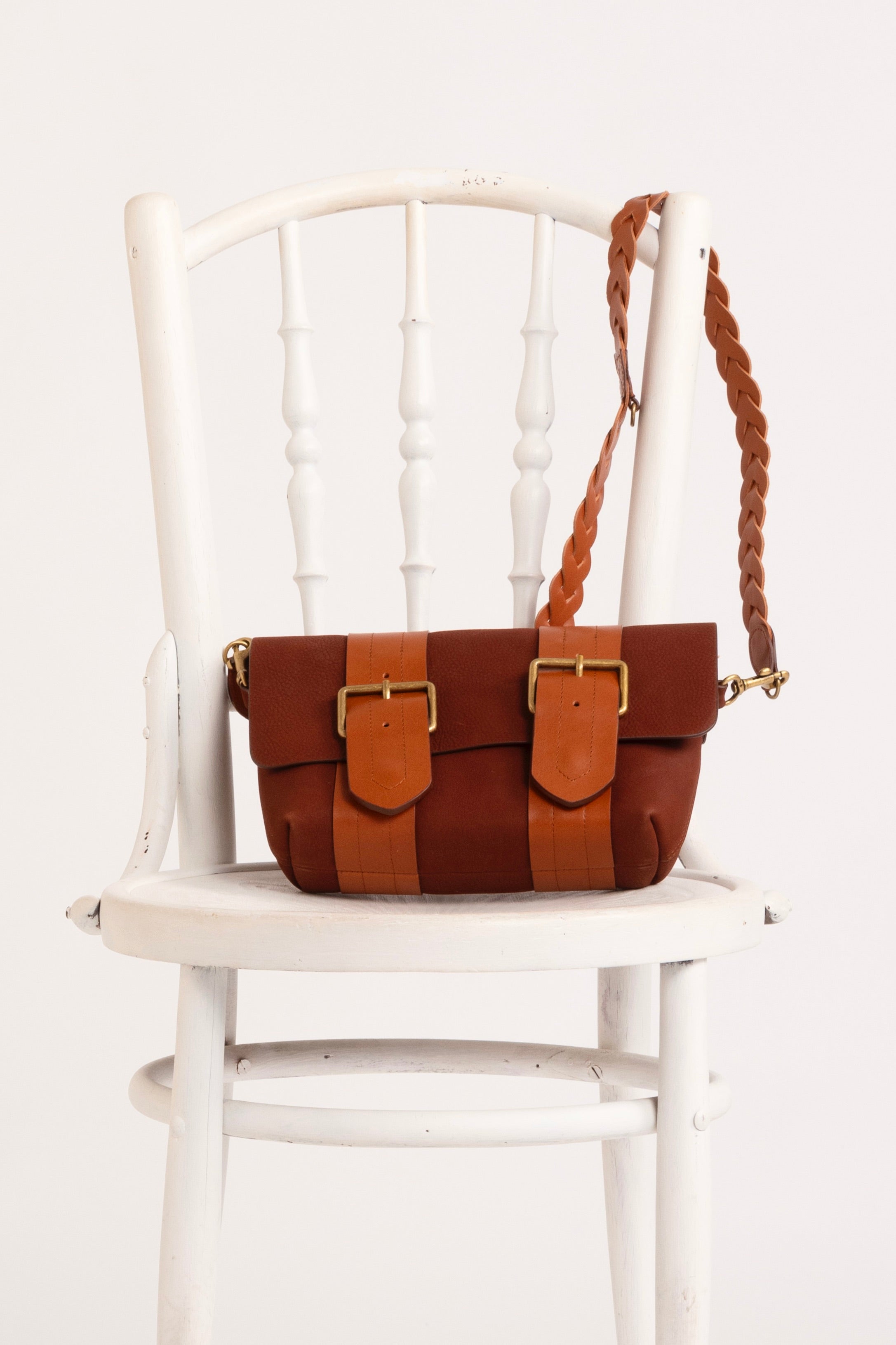 In situ image of orange bag sitting on a white chair.