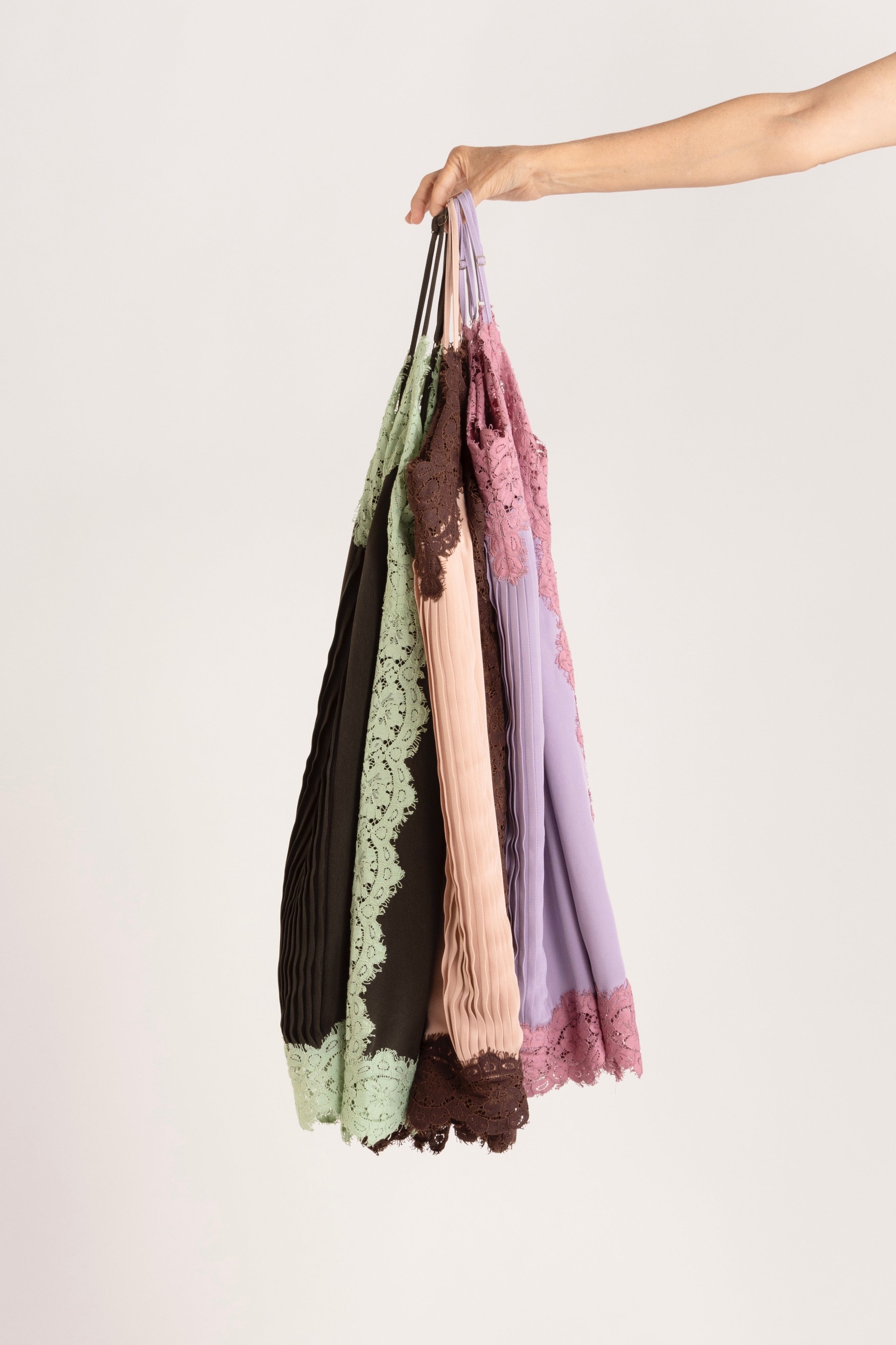 Model holding a selection of colourful cami's.