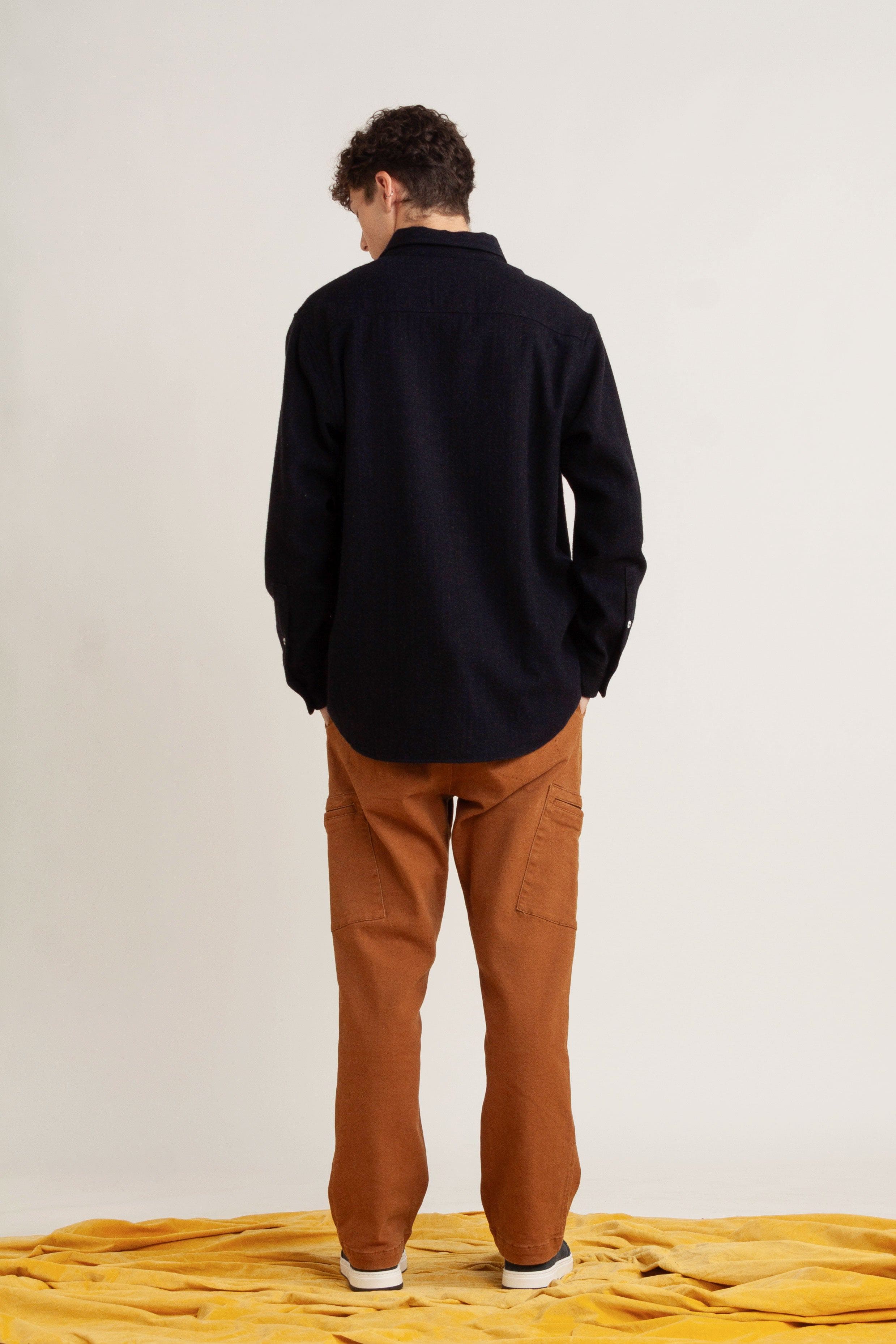 model wearing navy cotton long sleeve shirt, with burnt orange cotton pant and navy sneakers, back view