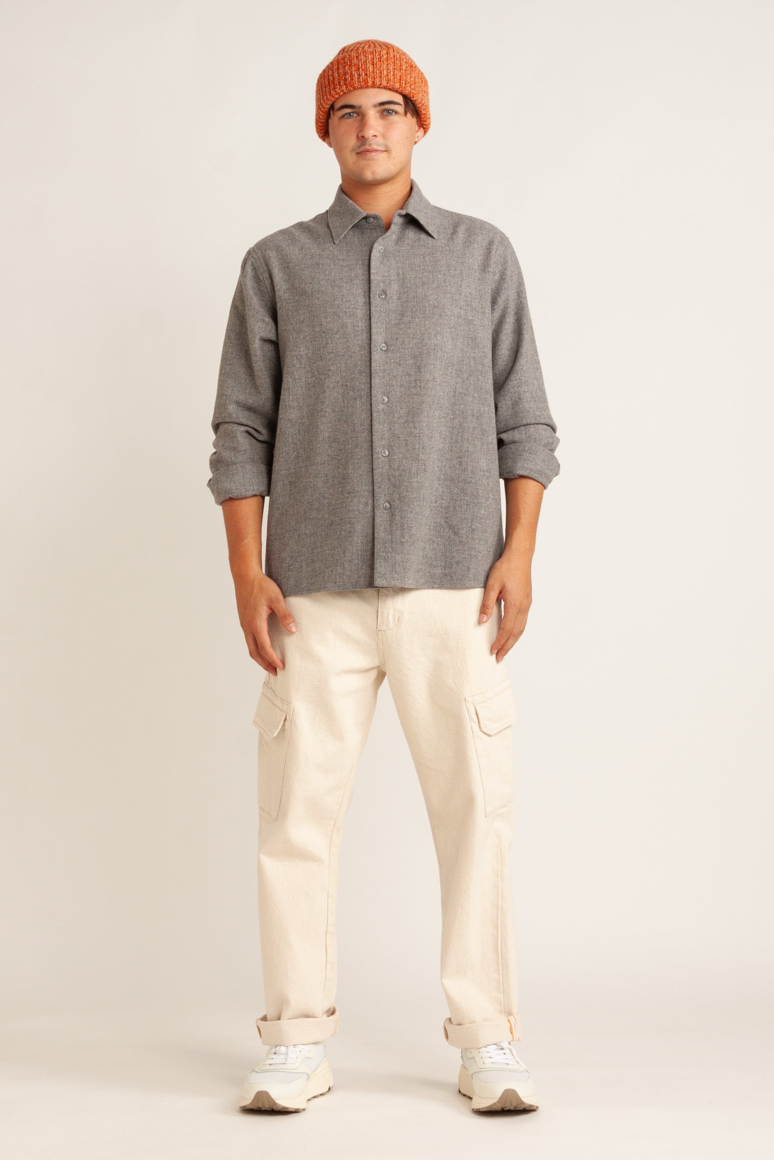Model wearing orange beanie, gray shirt, natural canvas pant and white sneaker, front view
