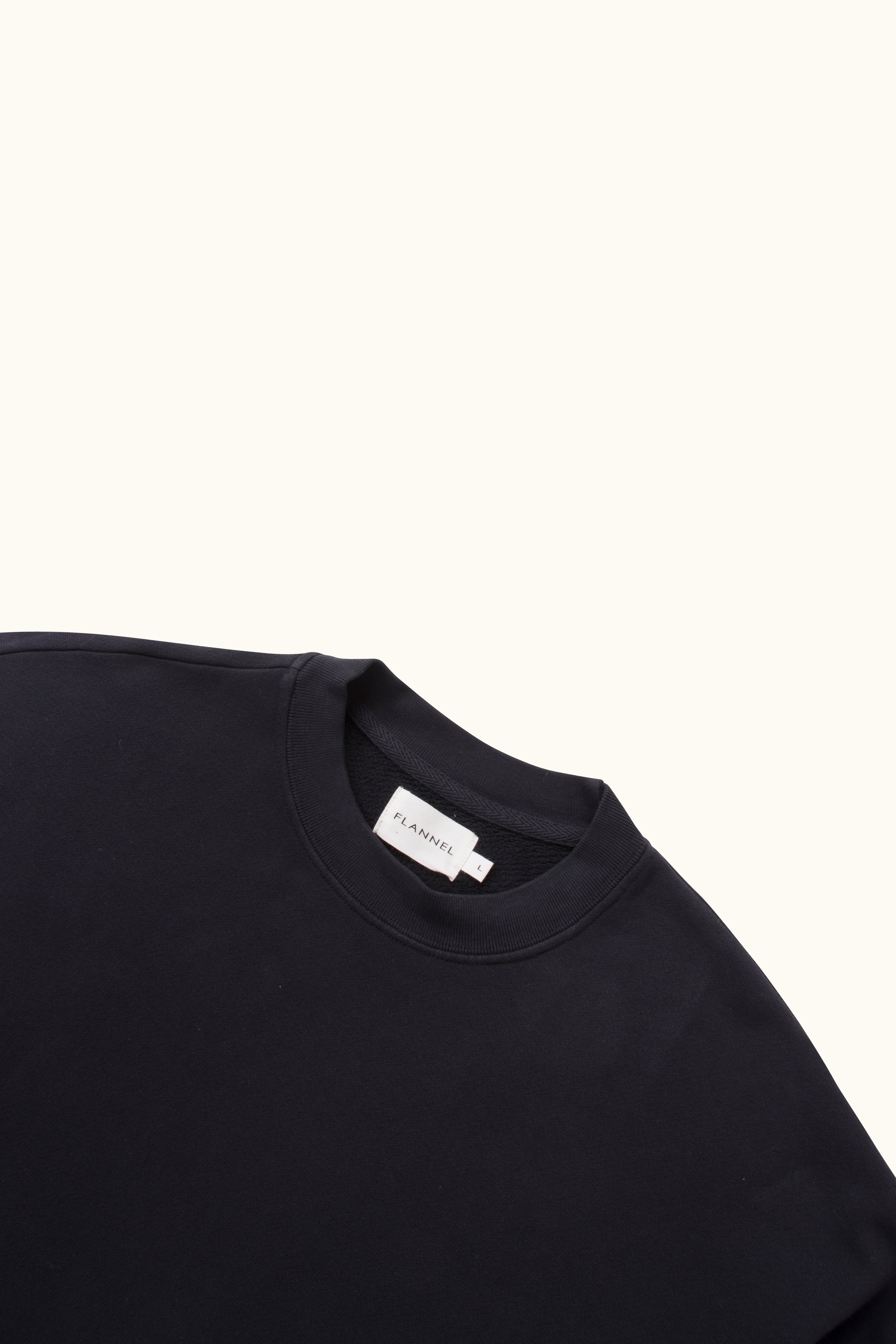 Close-up black sweatshirt with a brand label on a white background