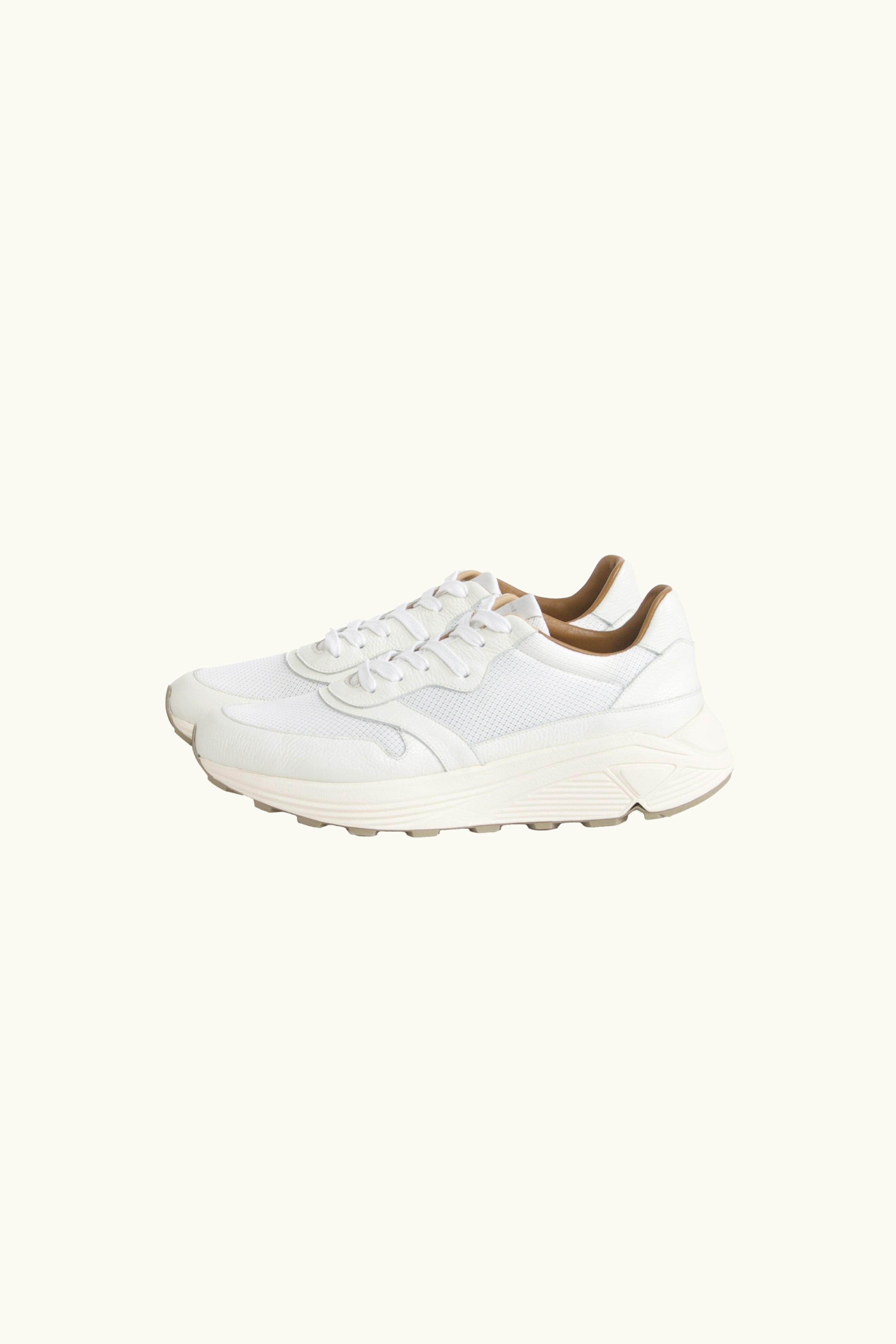 White sneaker with brown accents on a white background