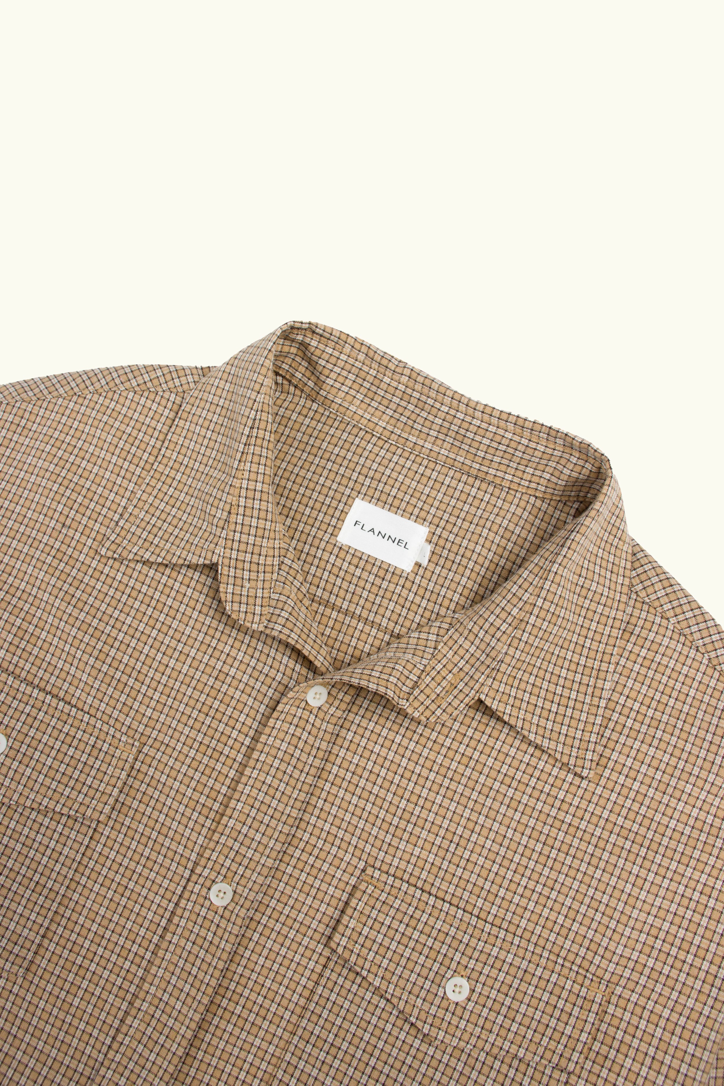 Close up of camel check cotton shirt on light background