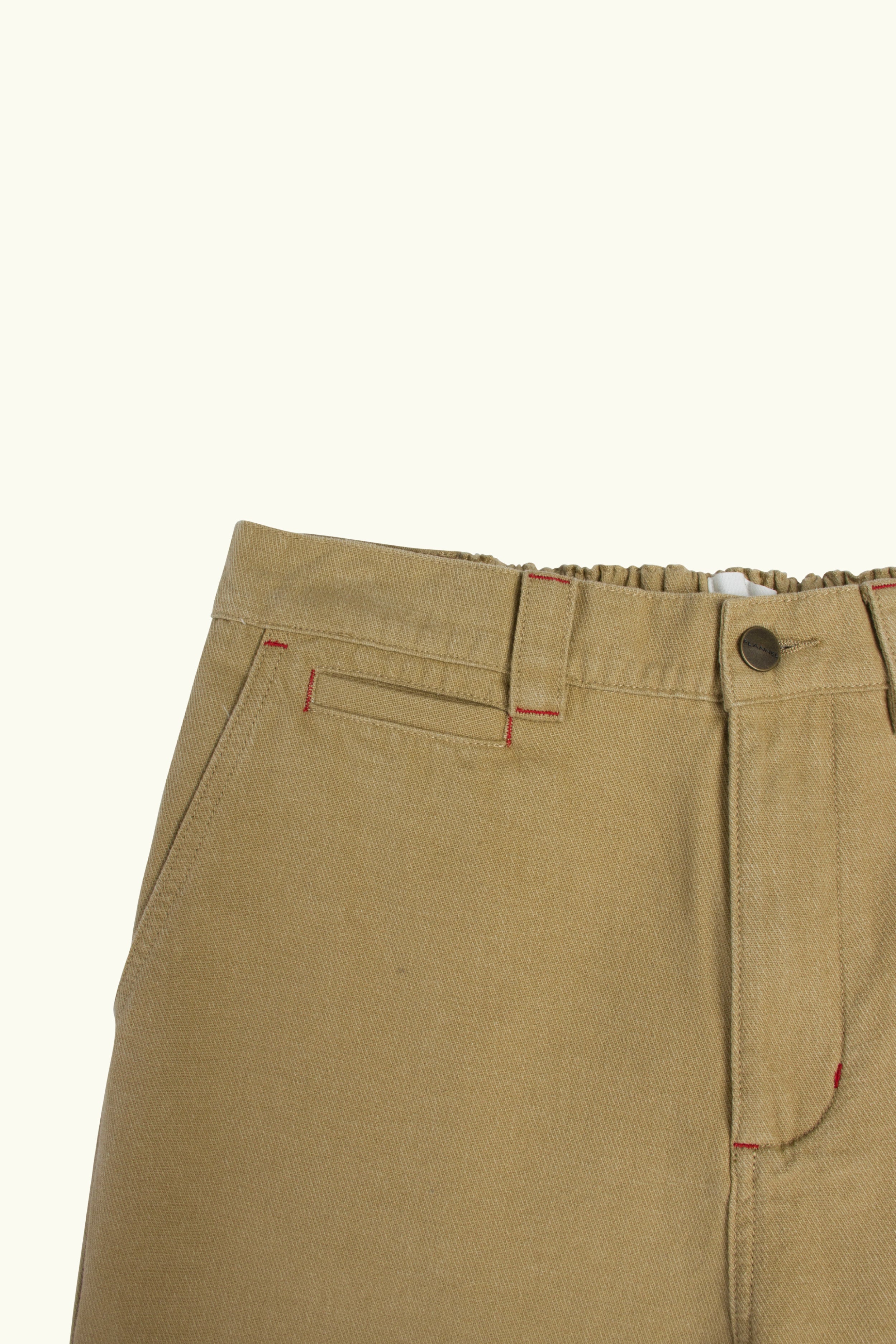 Close-up of Camel cotton pants with a button on a white background