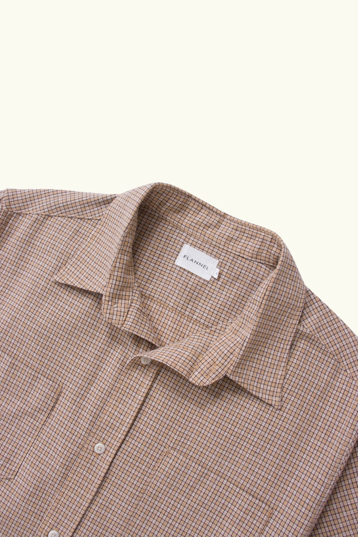 Close-up of a camel check shirt collar on a white background