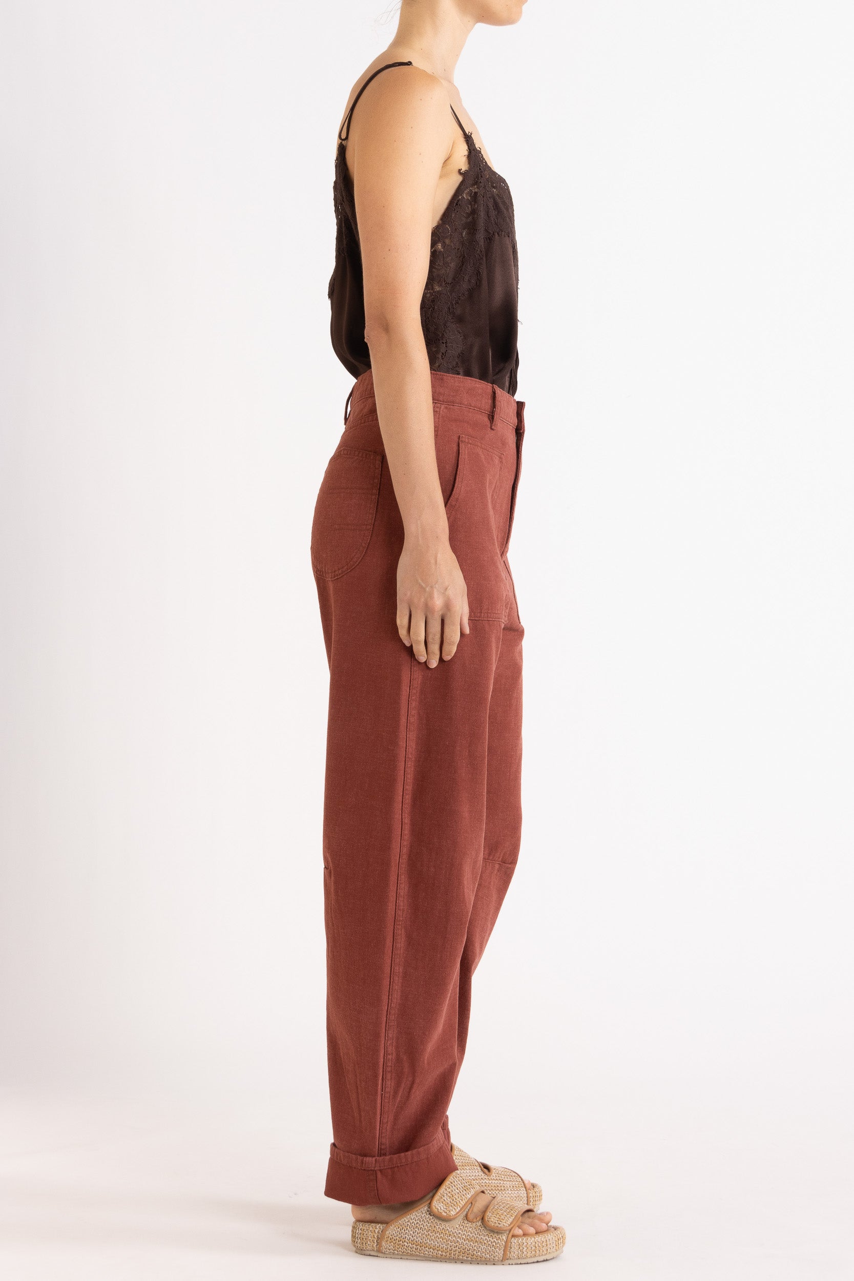 Model wearing chocolate satin cami with lace trims & burgundy cotton-twill pant, side view