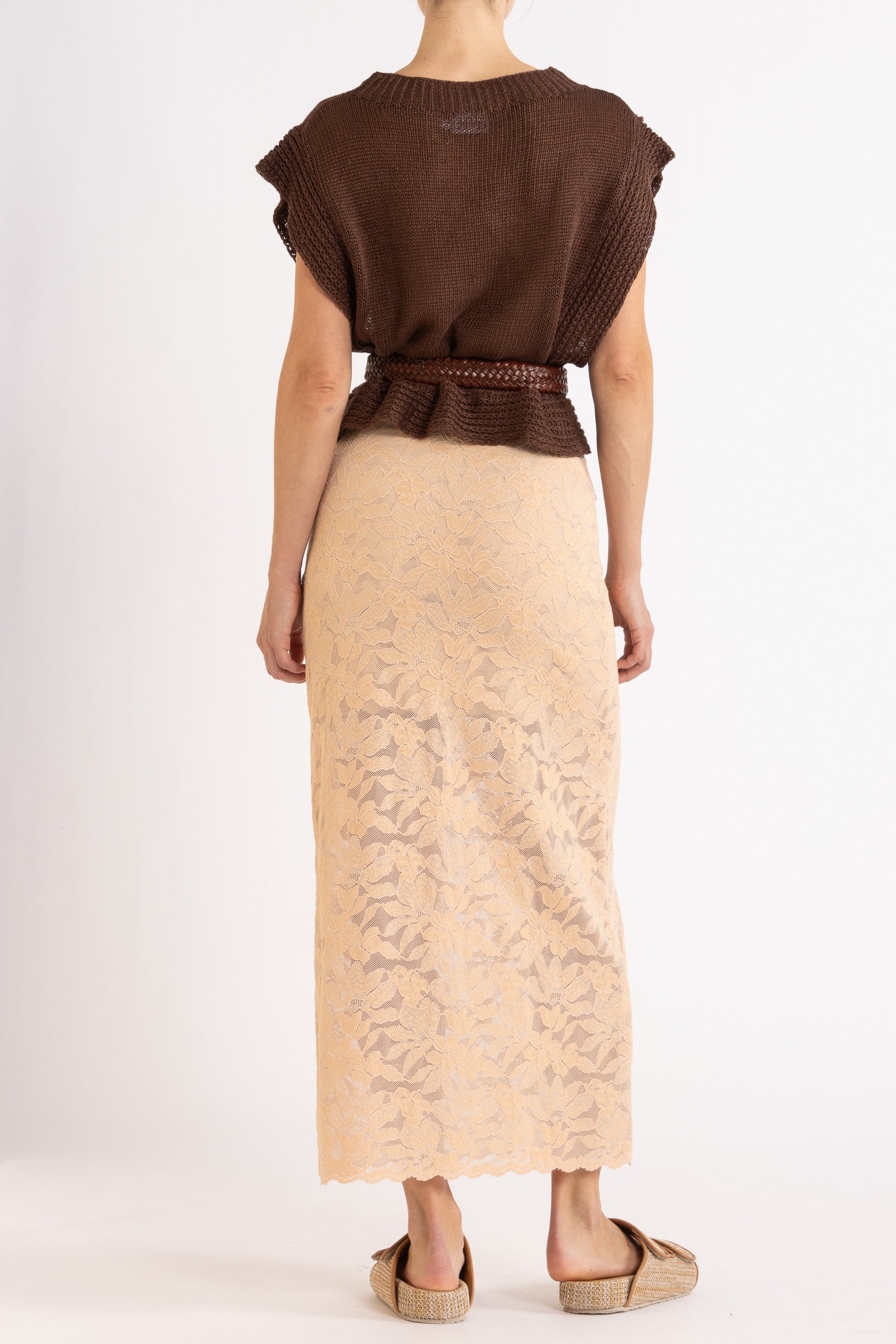 Woman wearing a brown linen vest, paired with a brown braided belt and a floral lace biscuit maxi skirt