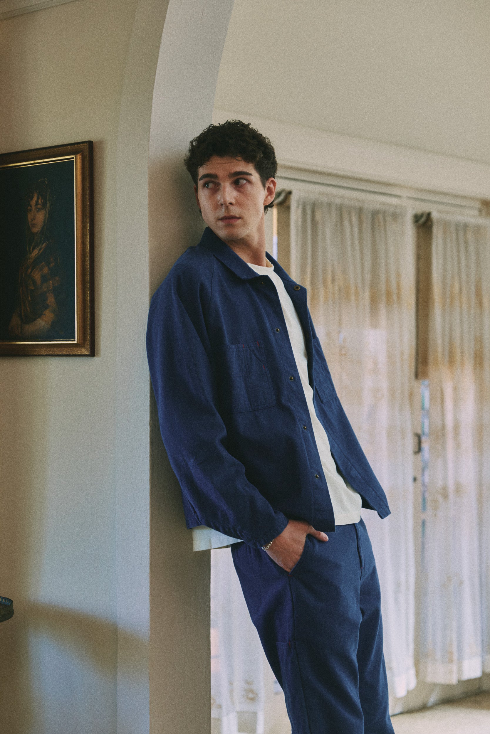 Model wears blue cotton jacket and pant with white cotton t-shirt, campaign image