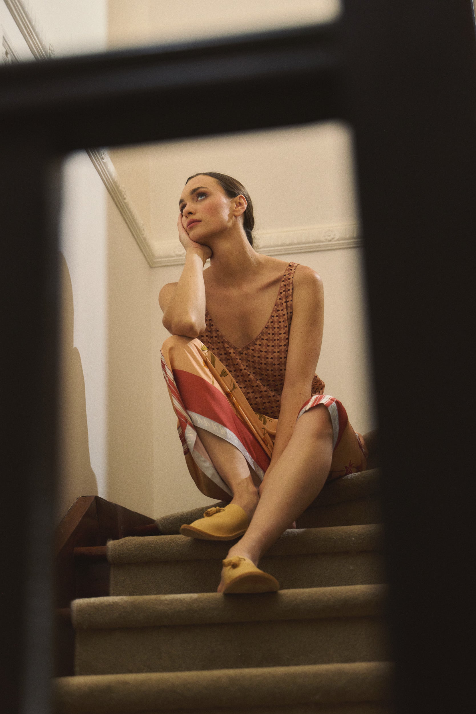 Model wearing peach patterned tank and printed skirt, campaign image