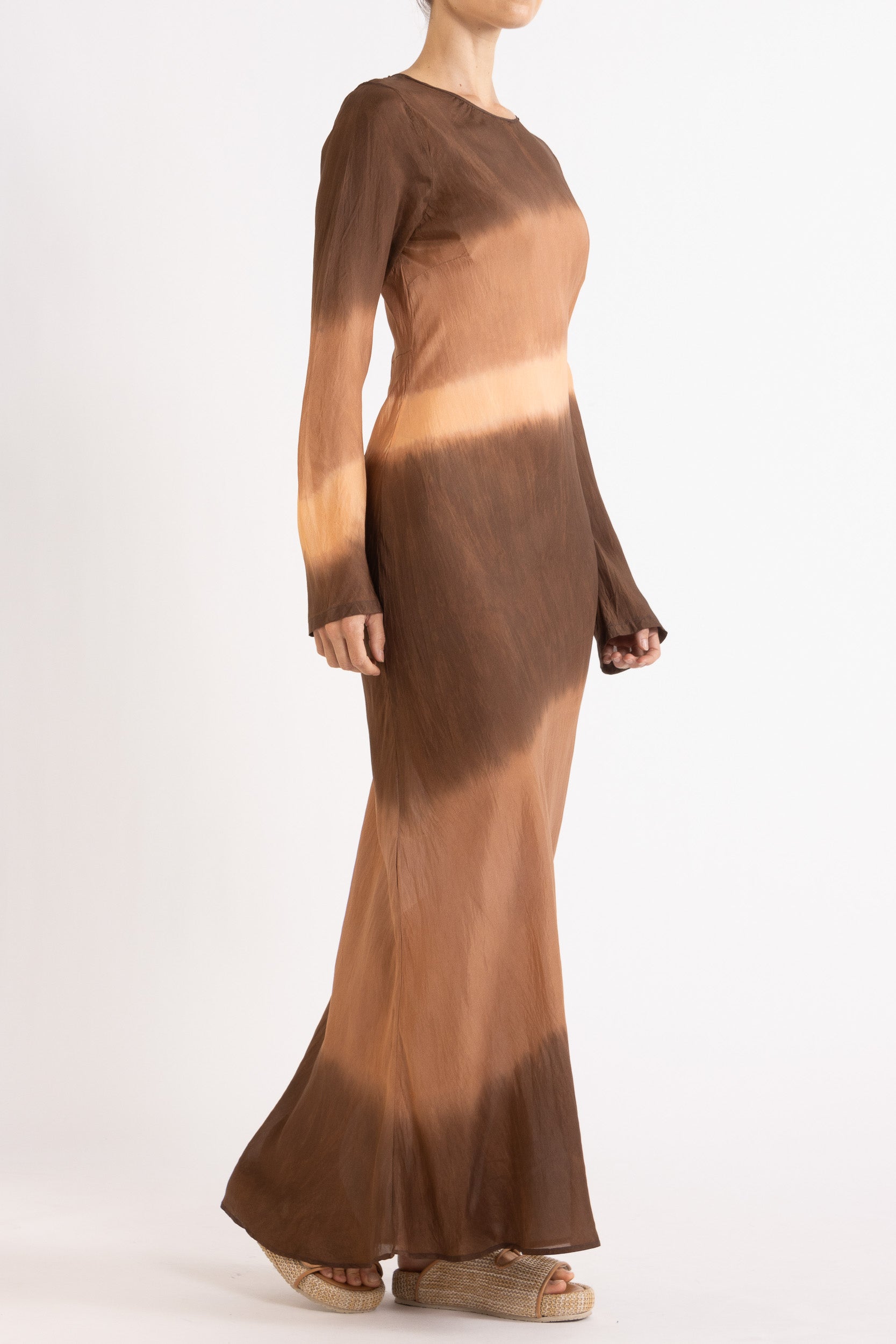Woman wearing a silk Habotai long Sleeve maxi dress hand tie dyed in earth tones