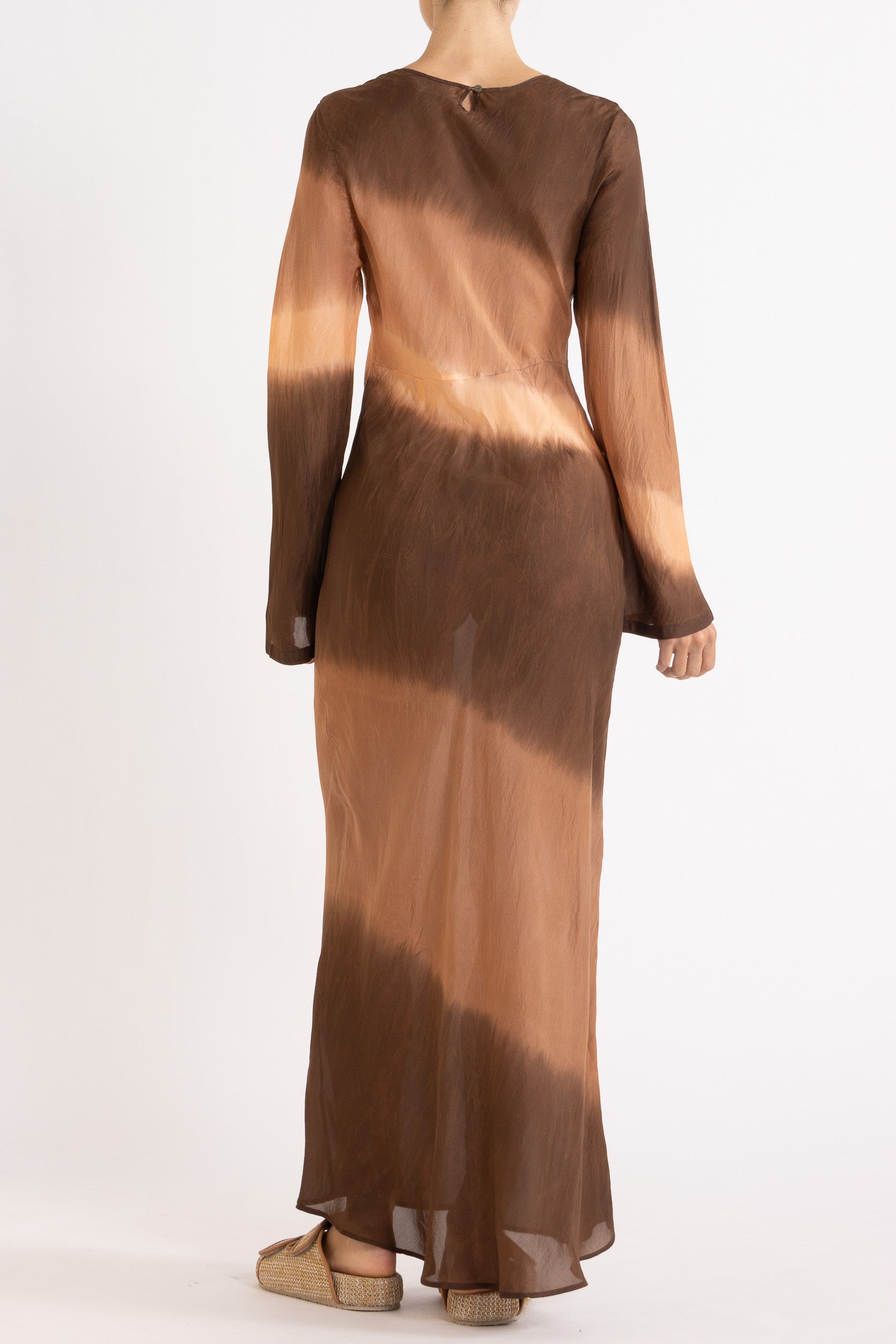 Woman wearing a silk Habotai long Sleeve maxi dress hand tie dyed in earth tones