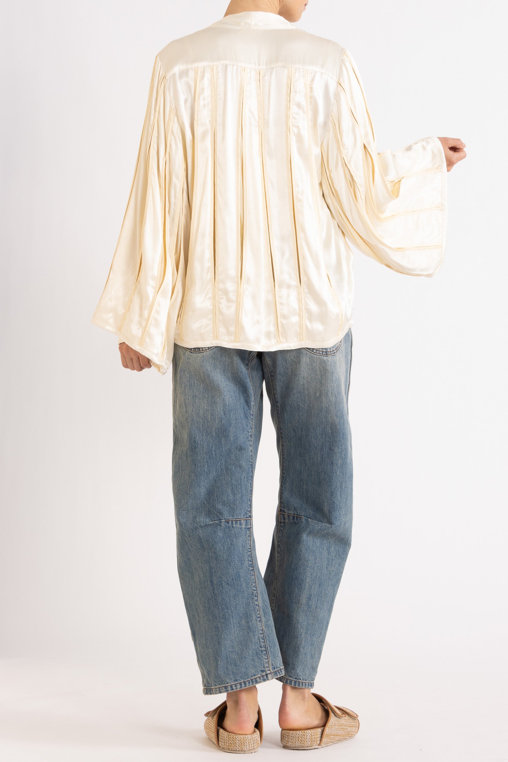 Model wearing cream box pleat jacket, white lace camisole & denim jean, back view