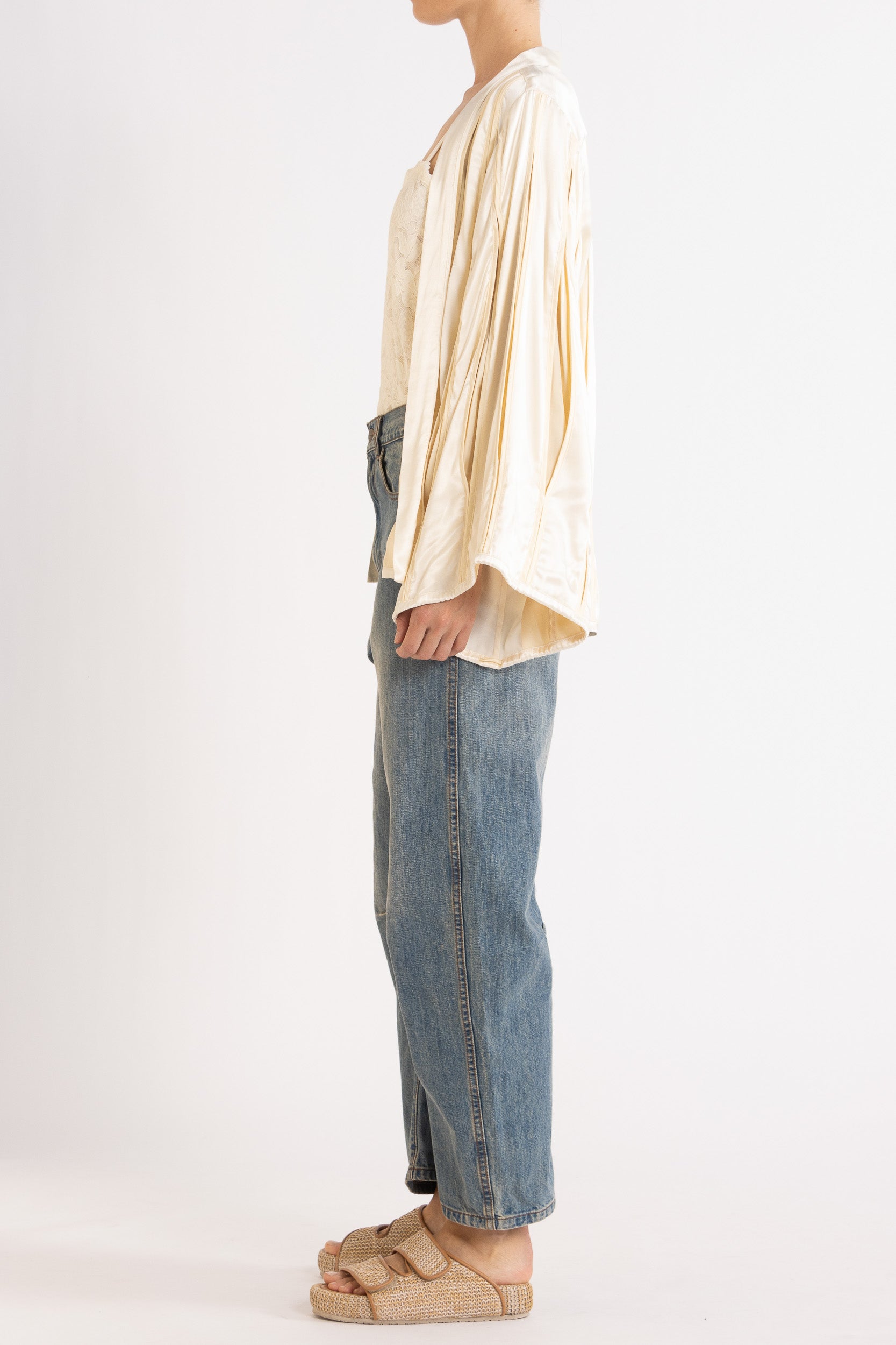 Model wearing cream box pleat jacket, white lace camisole & denim jean, side view