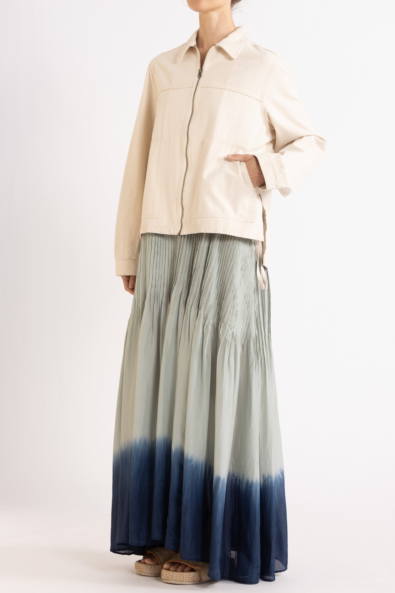 Model wearing cream cotton-twill utility jacket & sky blue dip-dye silk dress, front-side view