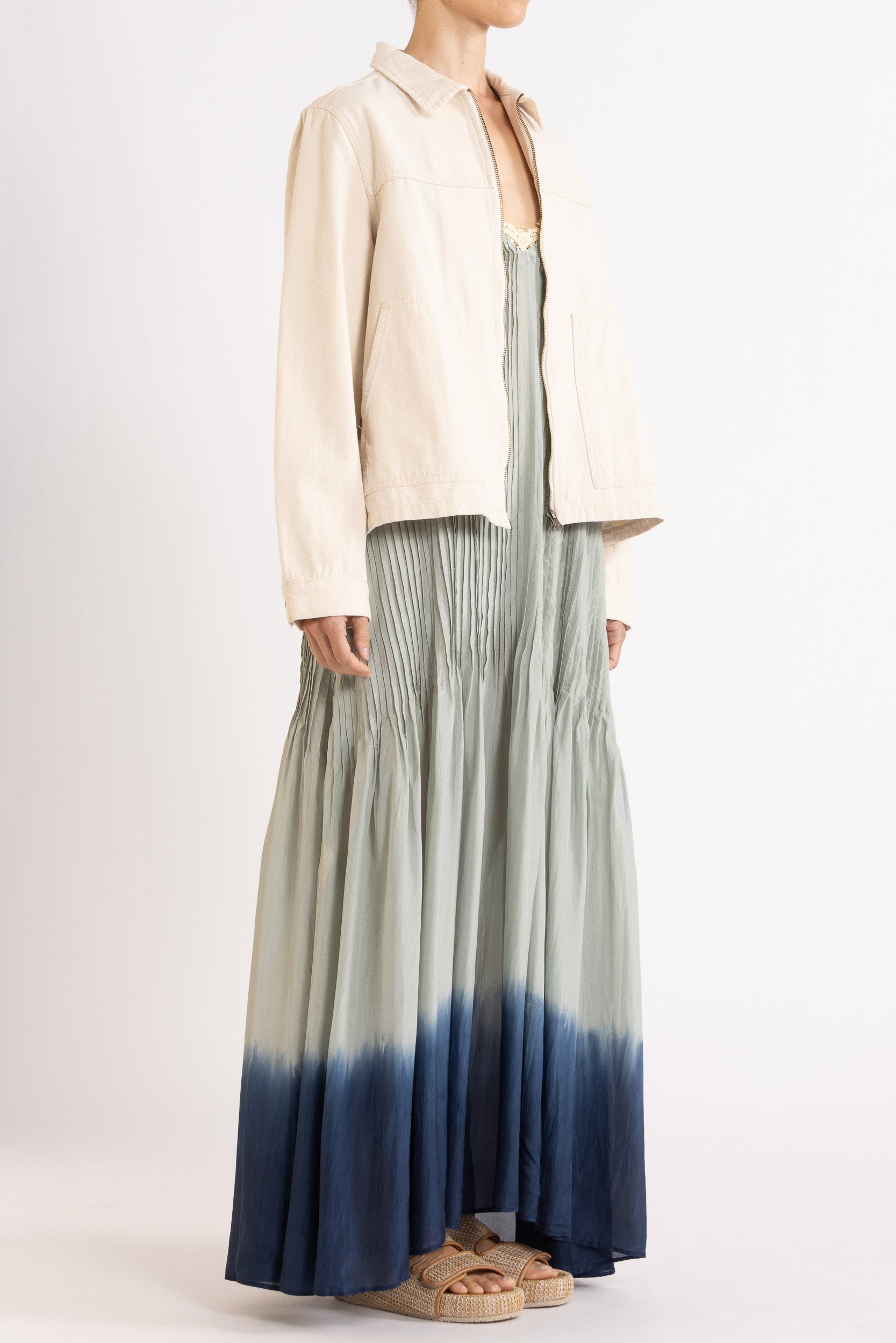 Model wearing cream cotton-twill utility jacket & sky blue dip-dye silk dress, front-side view