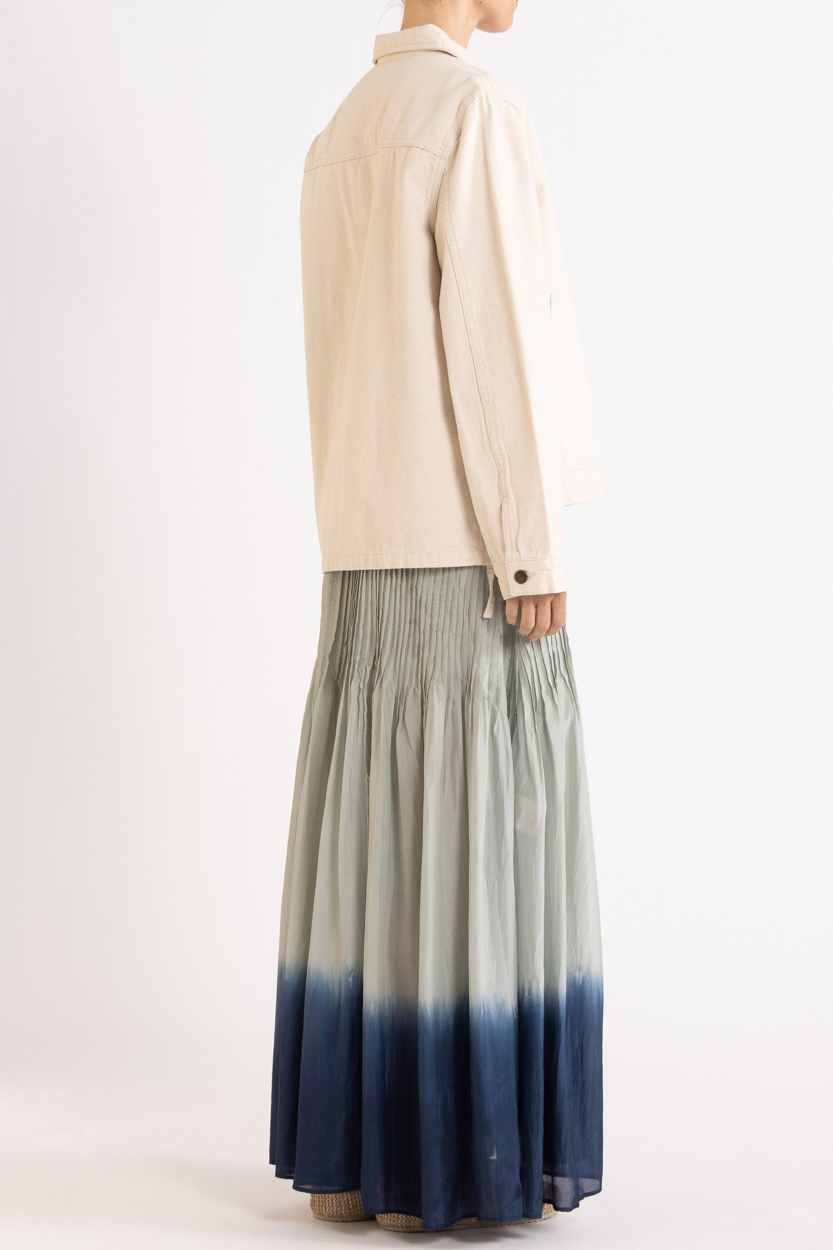 Model wearing cream cotton-twill utility jacket & sky blue dip-dye silk dress, back-side view