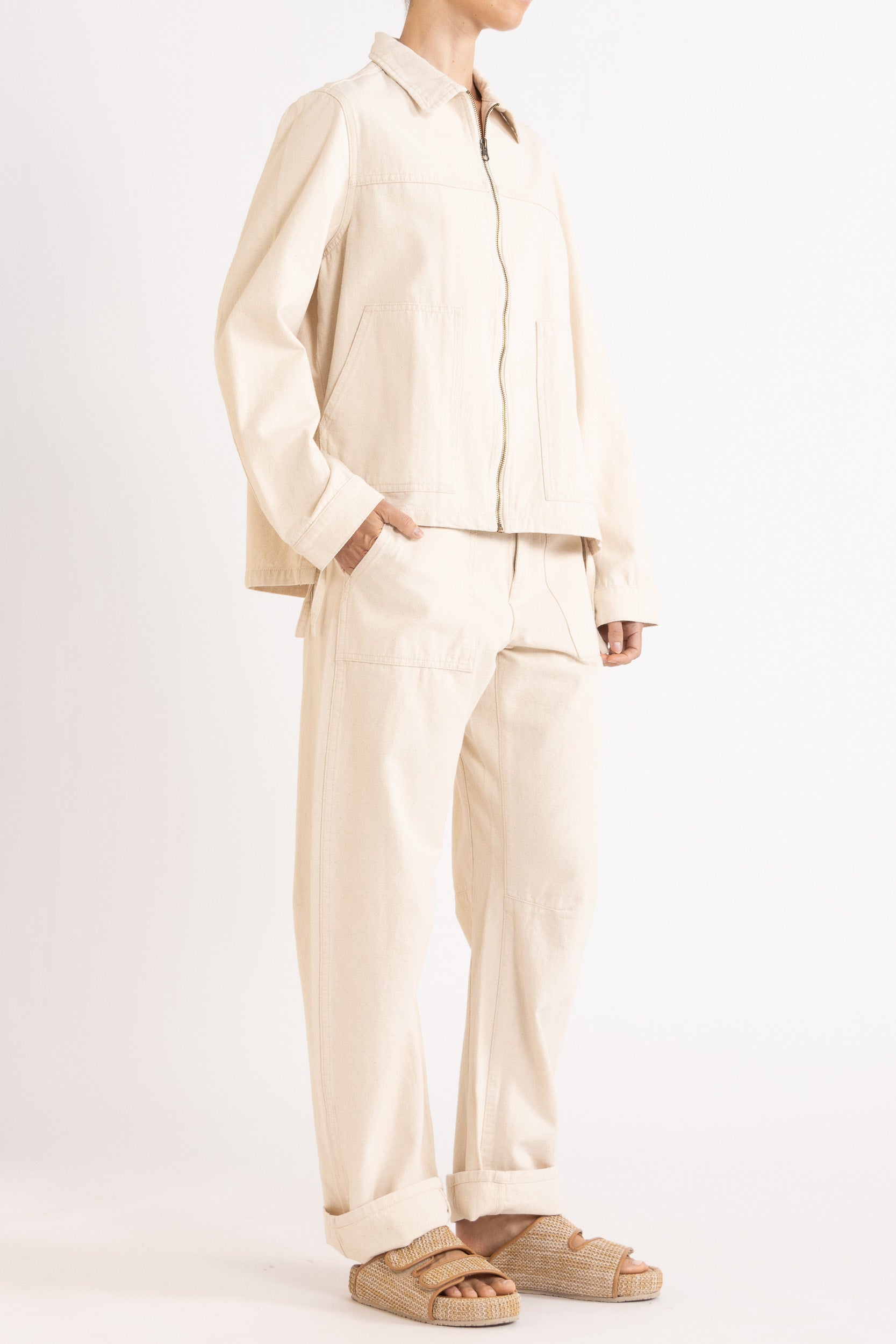 Model wearing cream cotton-twill utility jacket & pant, front-side view