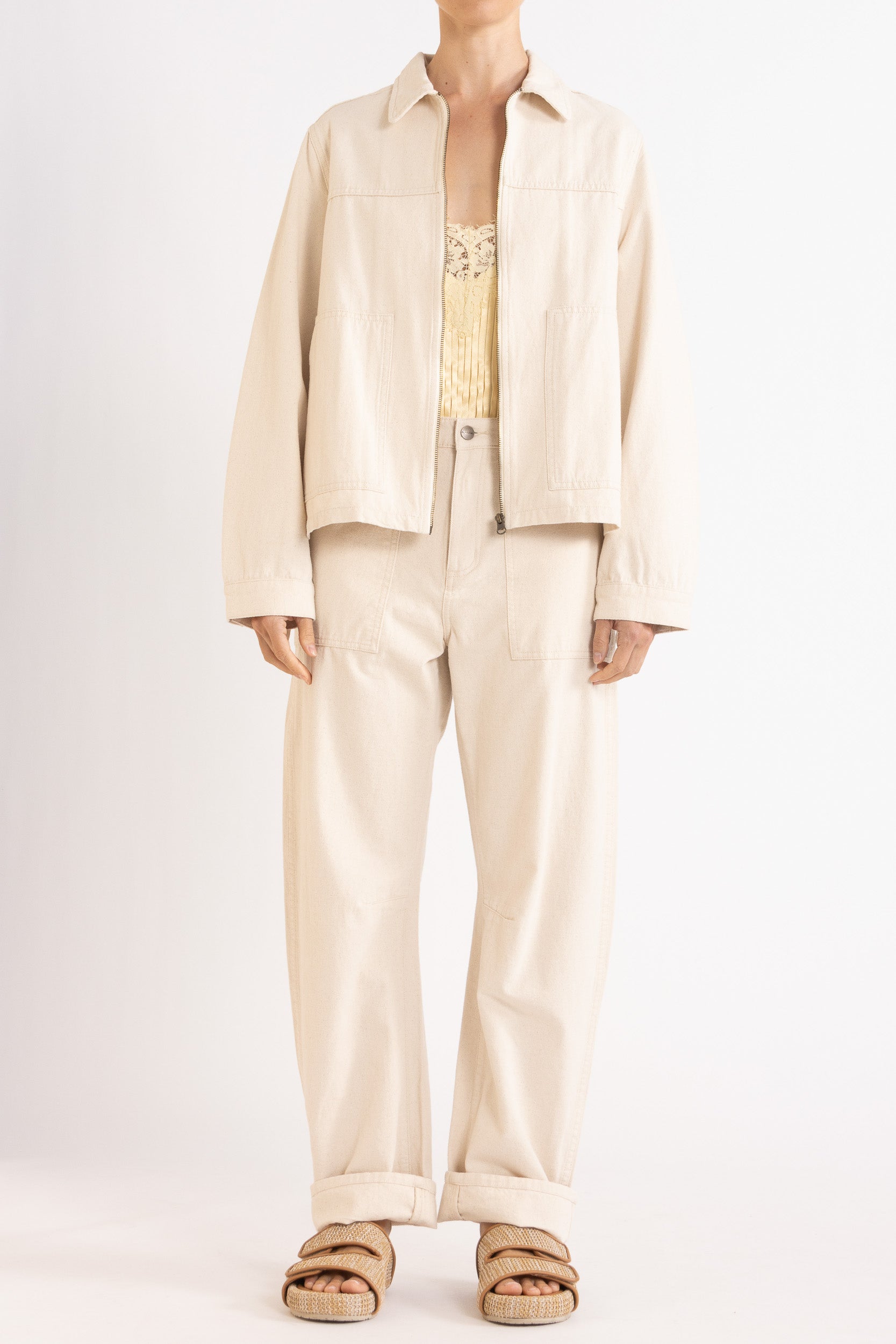 Model wearing cream cotton-twill utility jacket, pale yellow satin cami with lace trims & cream cotton-twill pant, front view