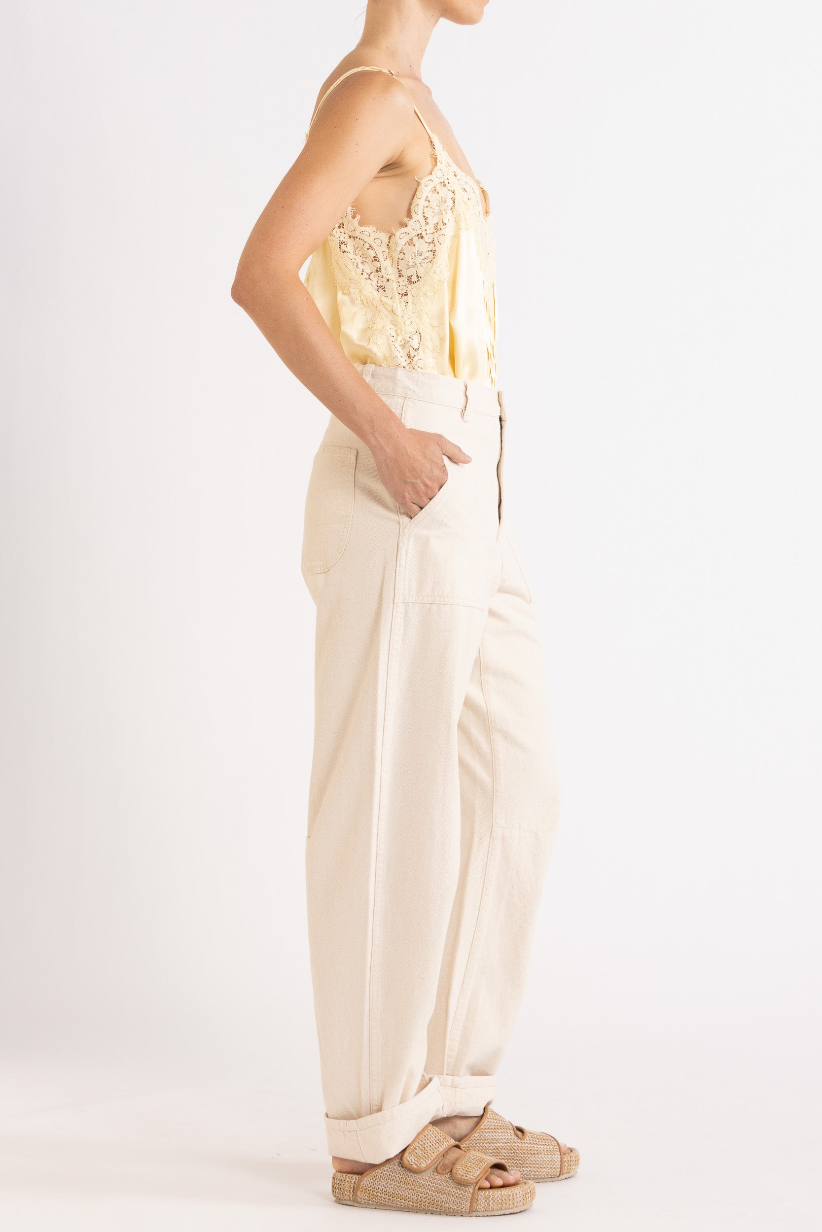 Model wearing pale yellow satin cami with lace trims & cream cotton-twill pant, side view