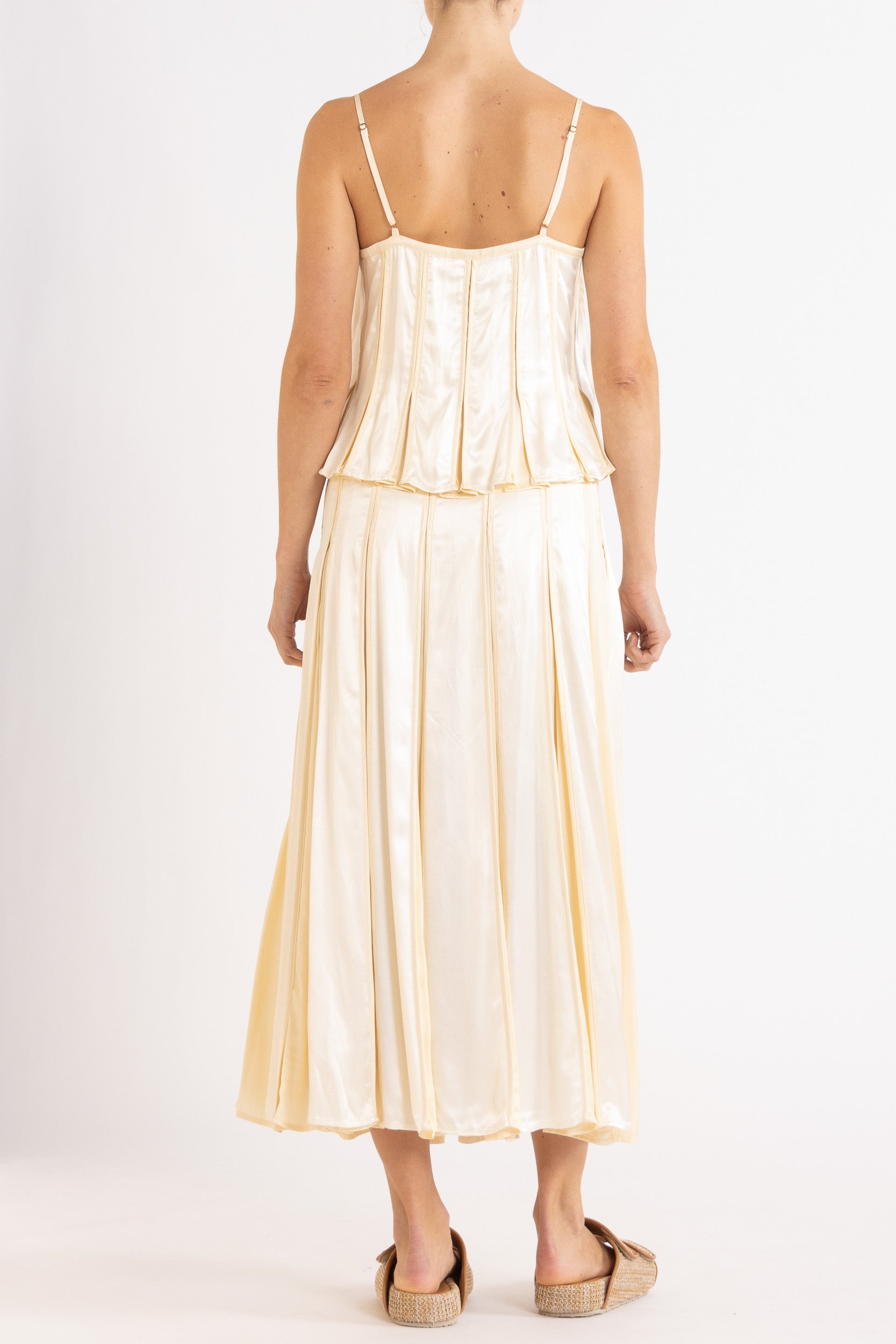 Model wearing cream box pleat skirt camisole & skirt, back view