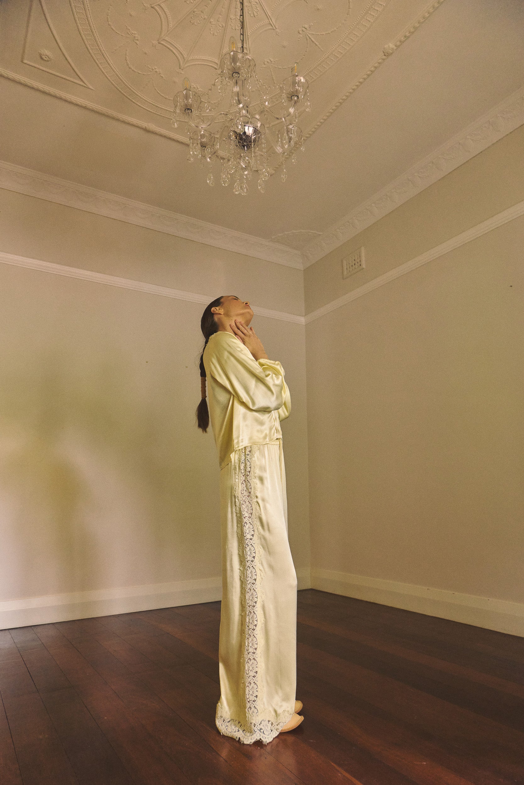 Woman in an empty room wearing matching vanilla lace lined long sleeve top and pant.