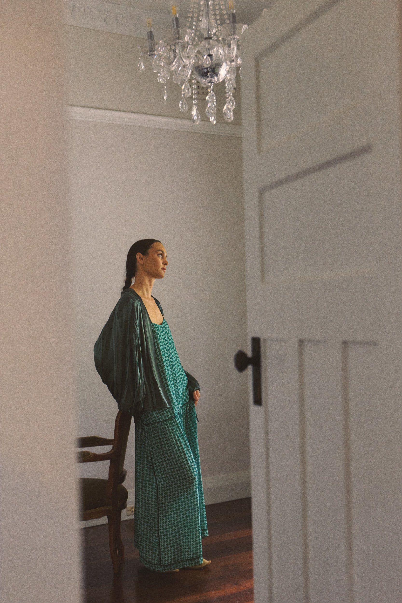 Model wearing green box pleat jacket & green patterned dress, campaign image