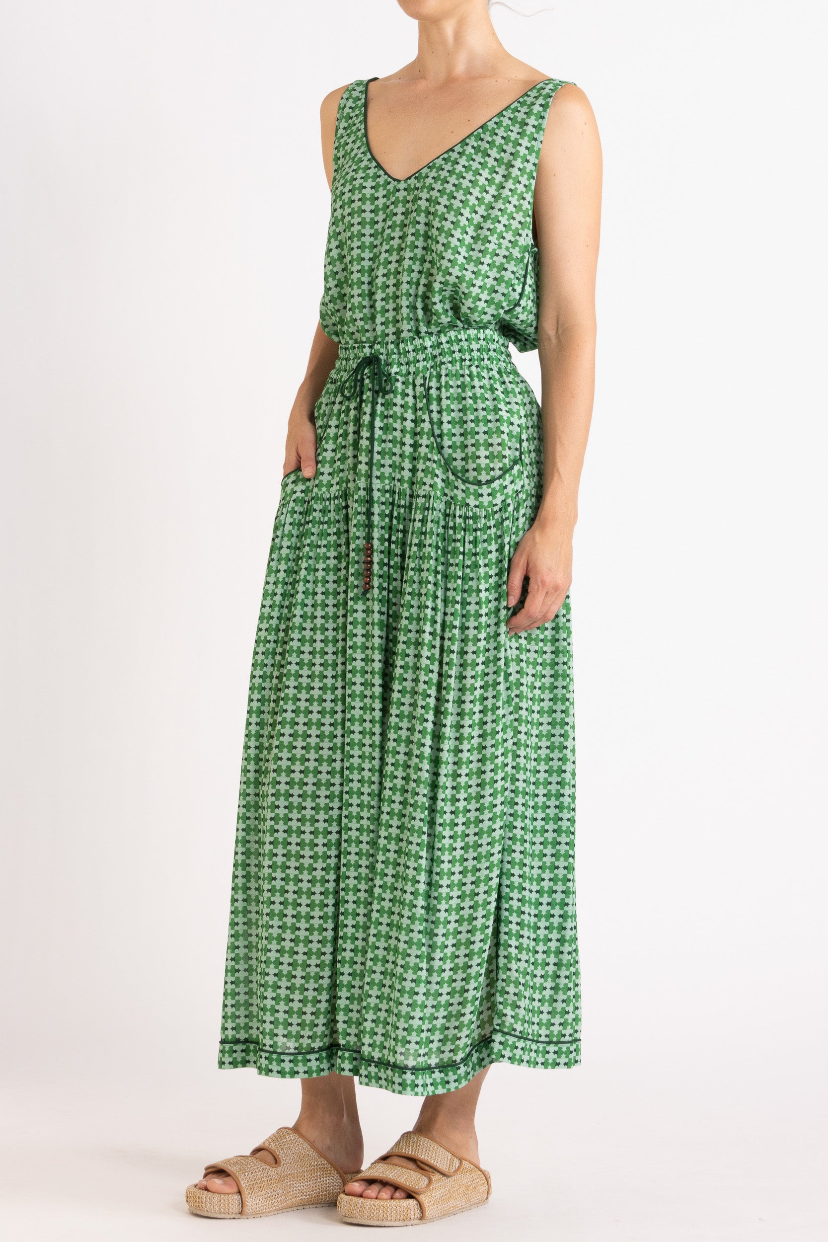 Model wearing green patterned tank top and skirt, front view