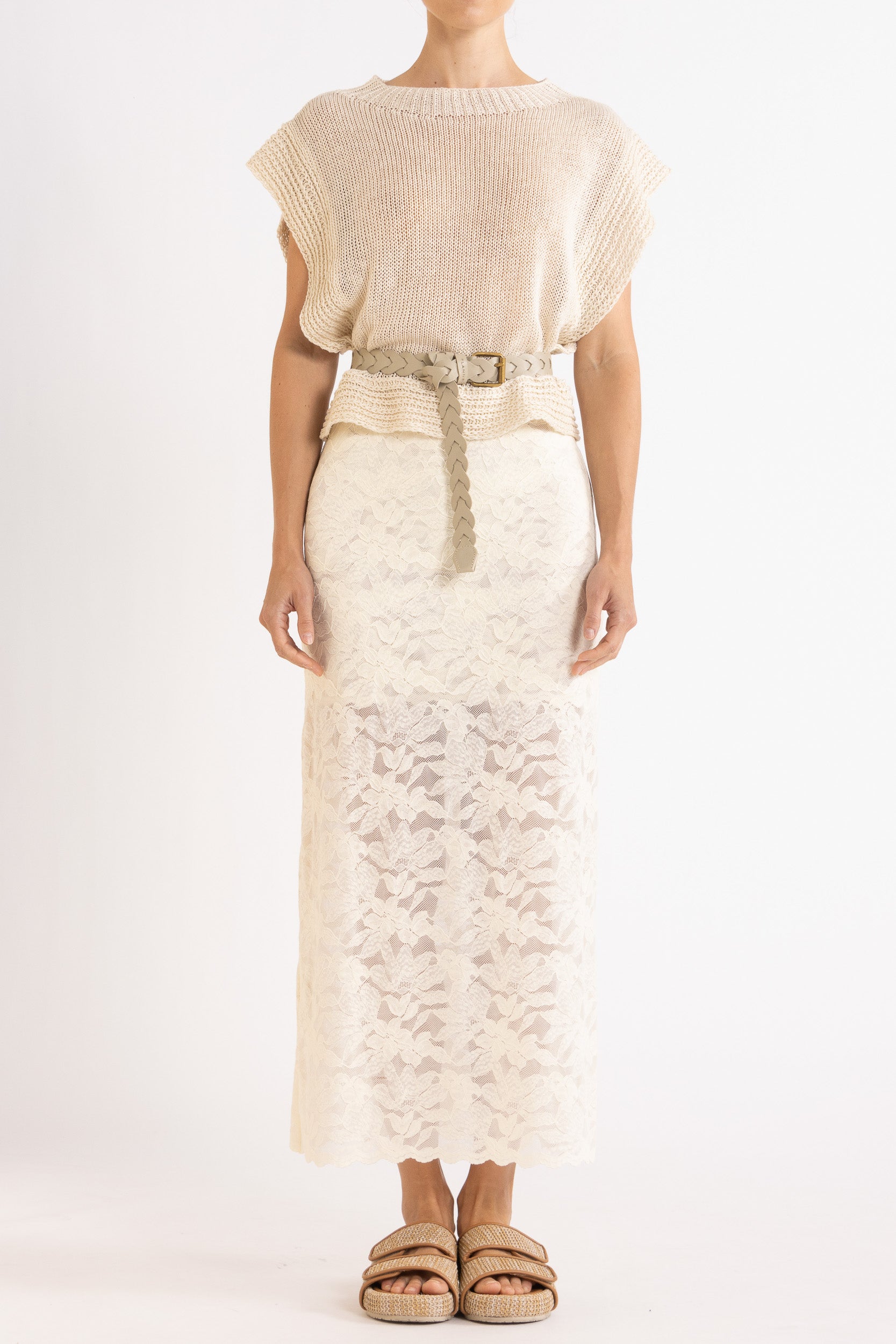 Woman wearing an oat linen vest with a cream braided best and white lace maxi skirt