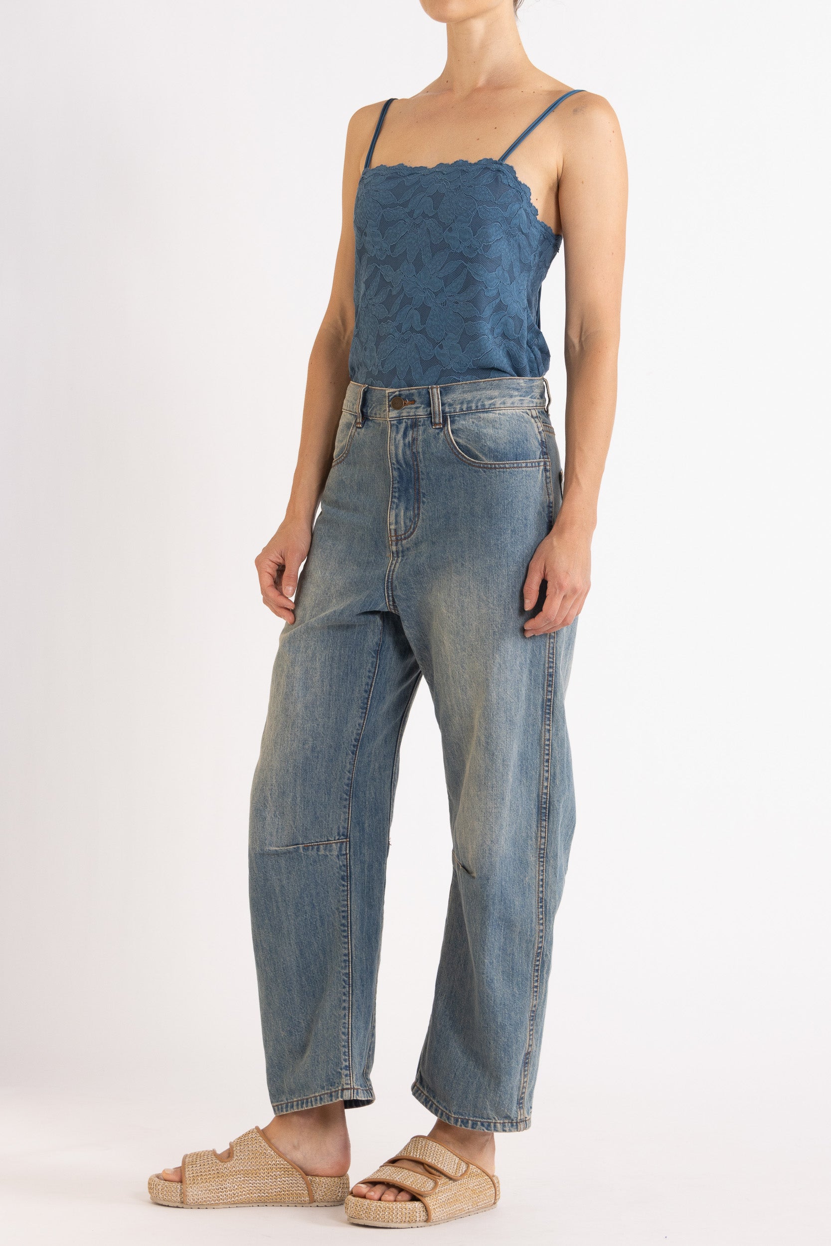 Woman wearing blue floral lace camisole with denim bow-leg jeans