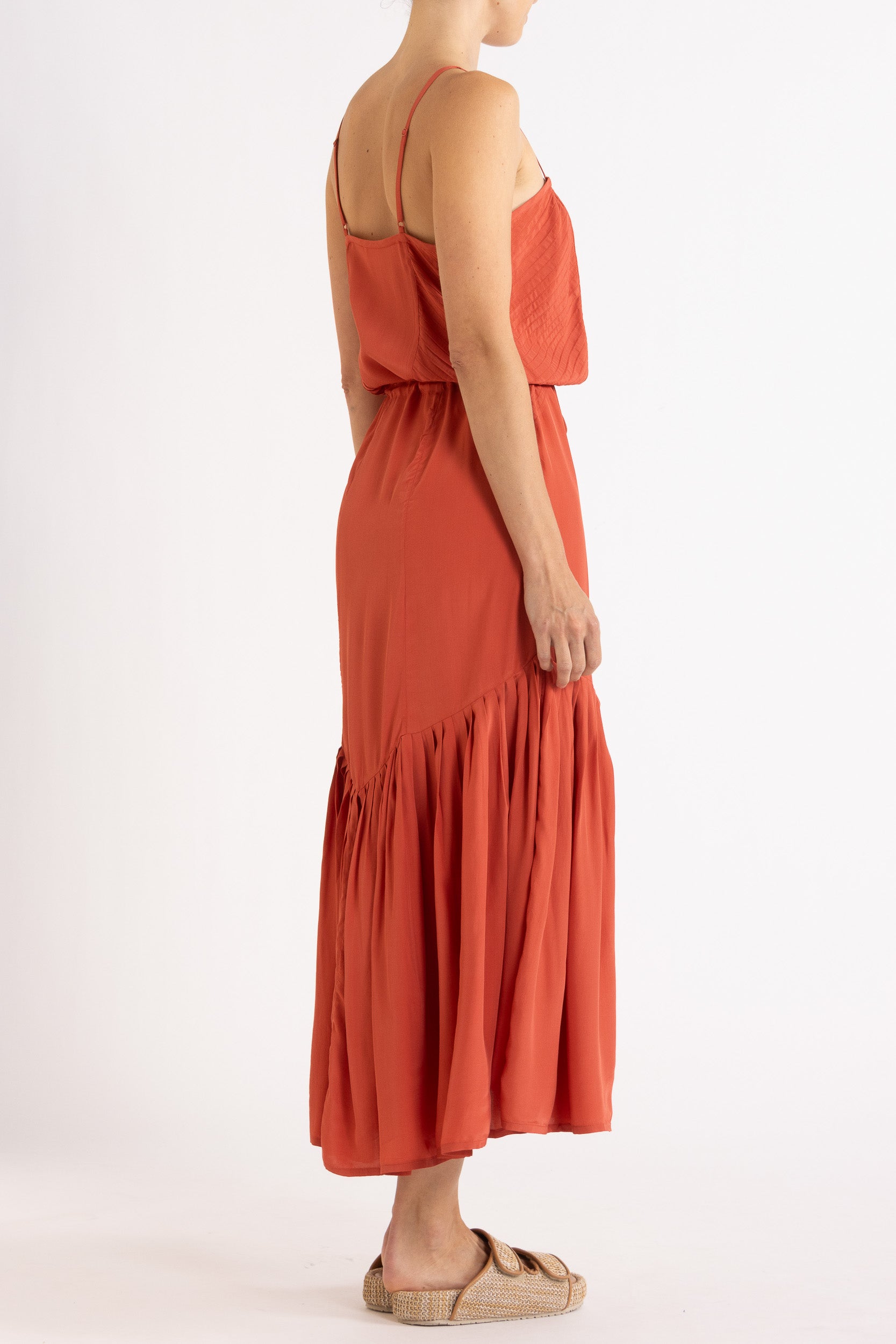 Woman wearing a red dress with floral embroidery on a white background