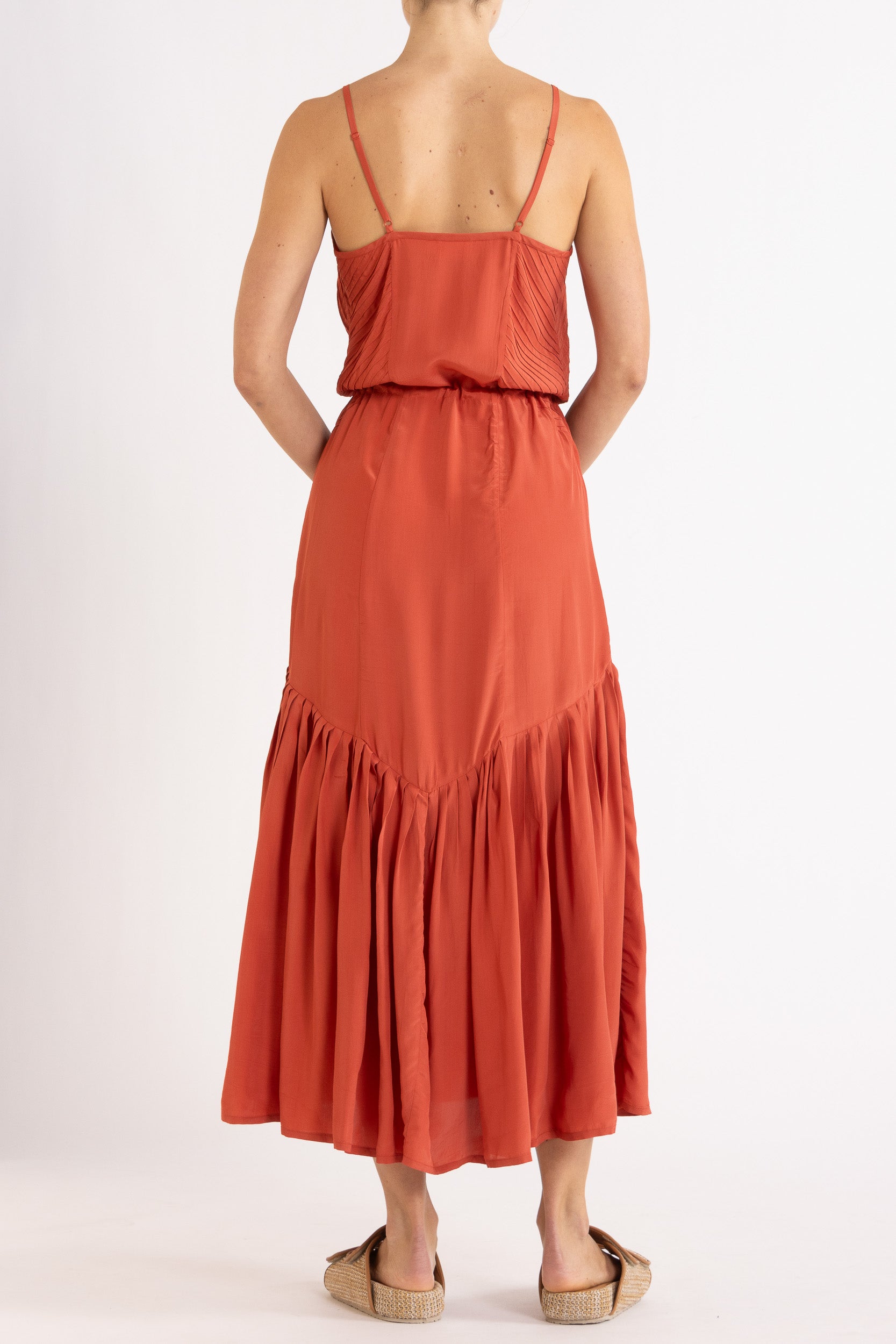 Woman wearing a red dress with floral embroidery on a white background