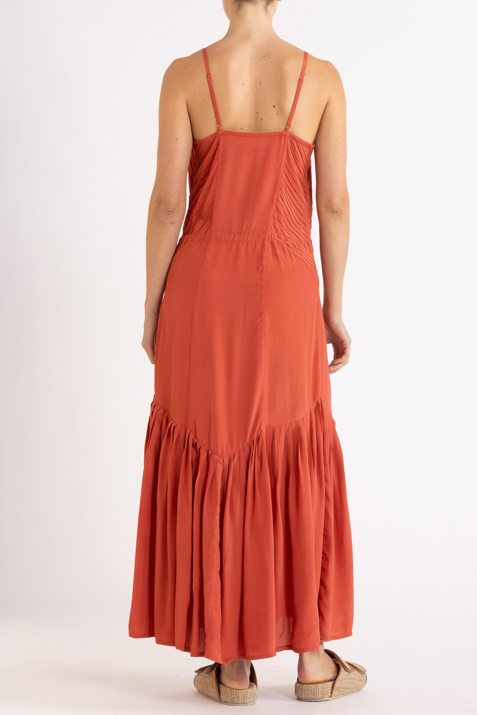 Woman wearing a red dress with floral embroidery on a white background