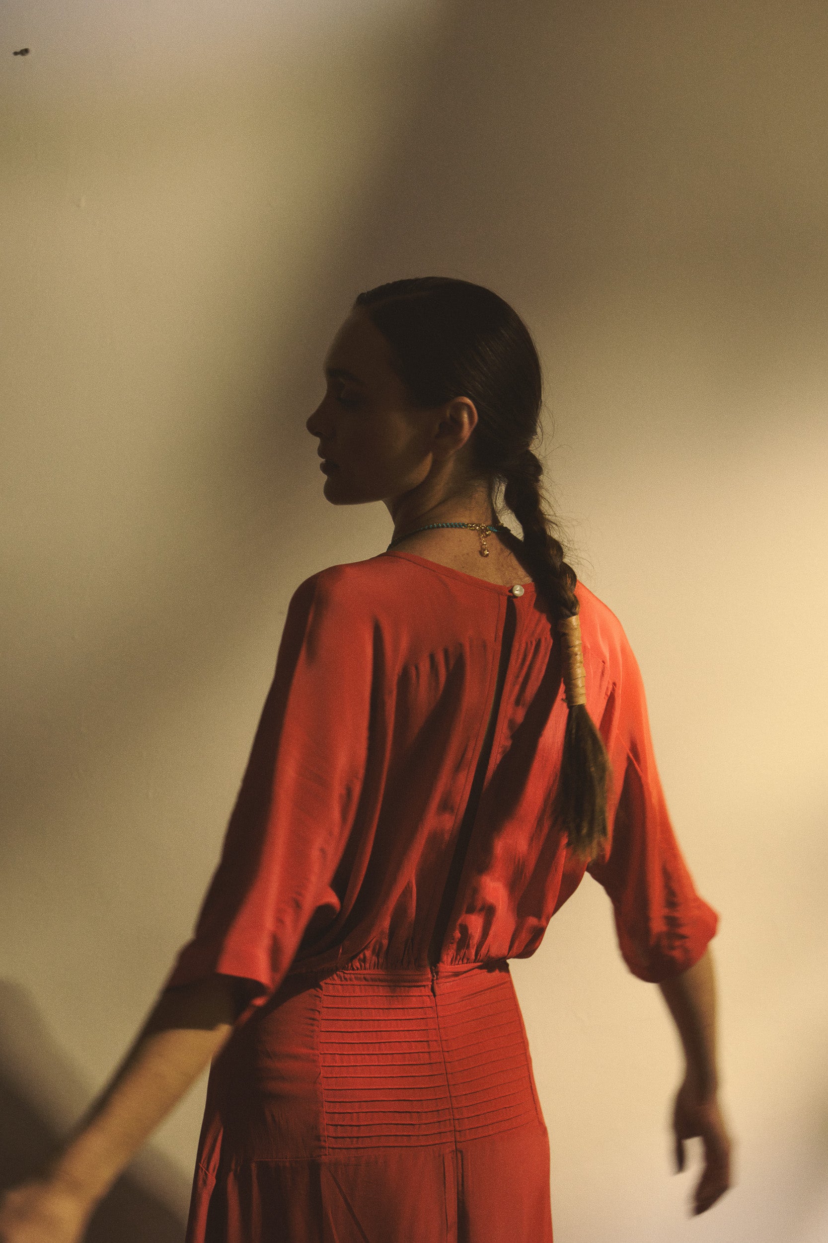 Woman wearing a red dress with floral embroidery on a white background