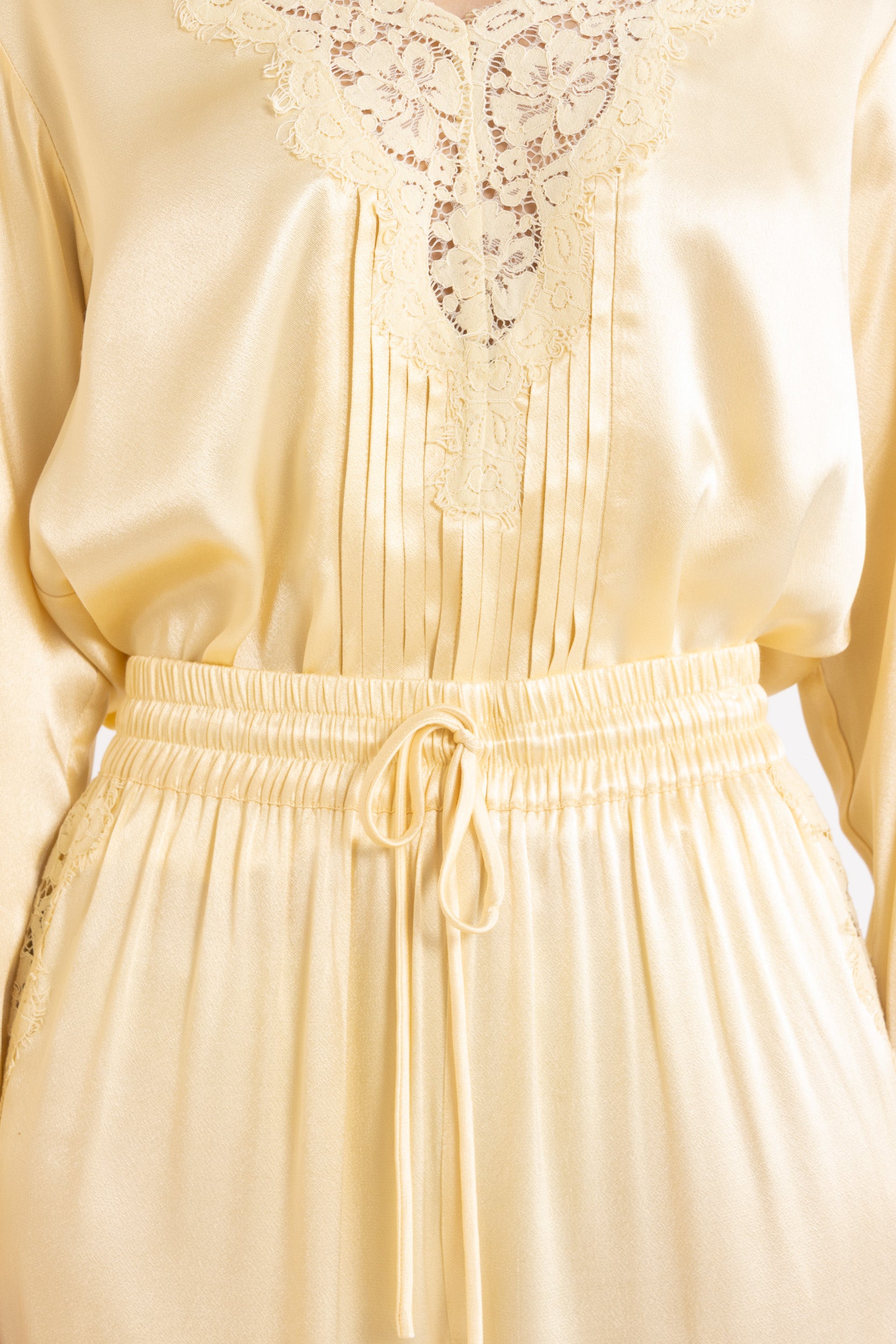 Woman wearing matching Vanilla lace-lined long sleeve top and pant on a white background