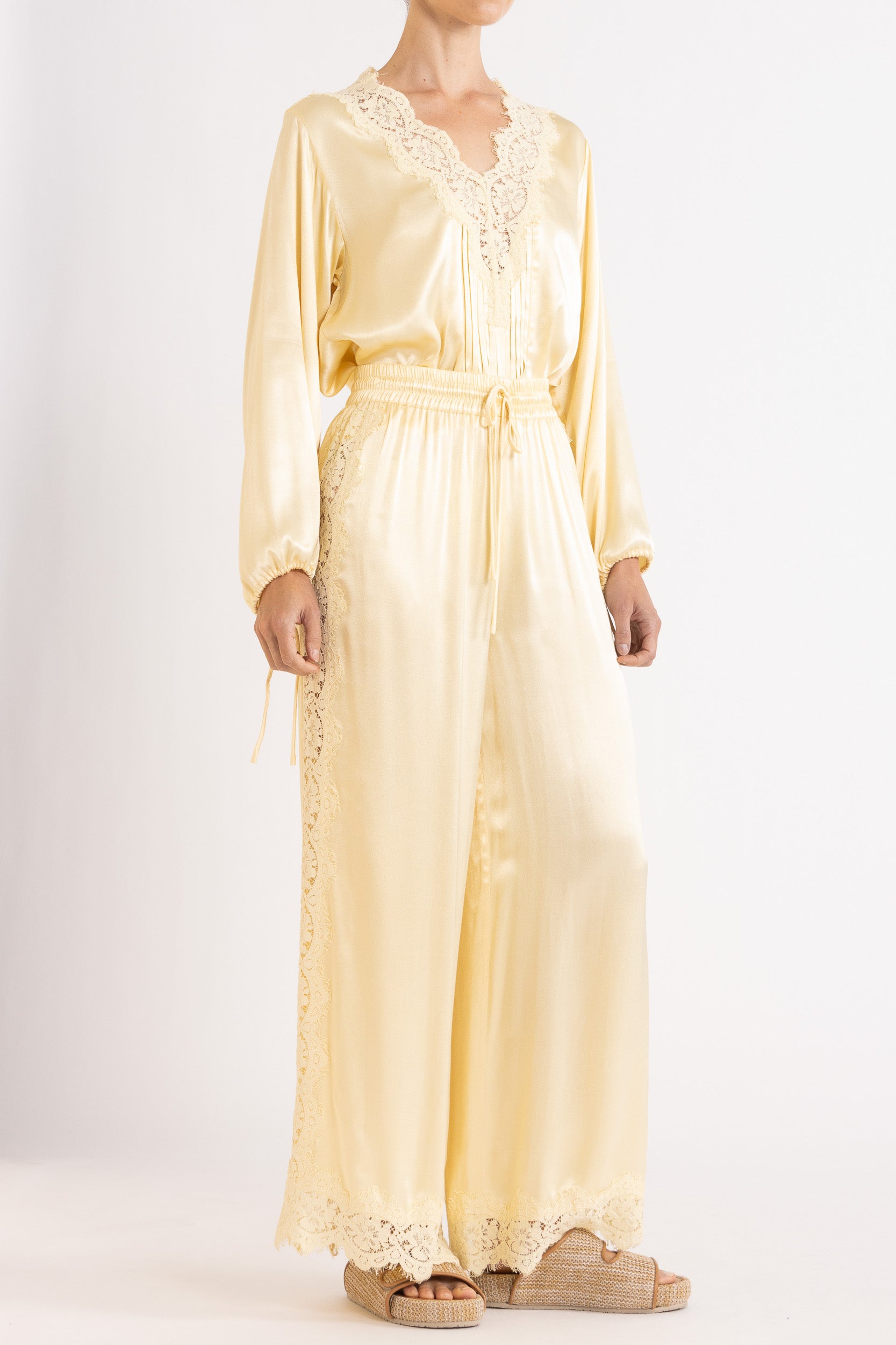 Woman wearing matching Vanilla lace-lined long sleeve top and pant on a white background