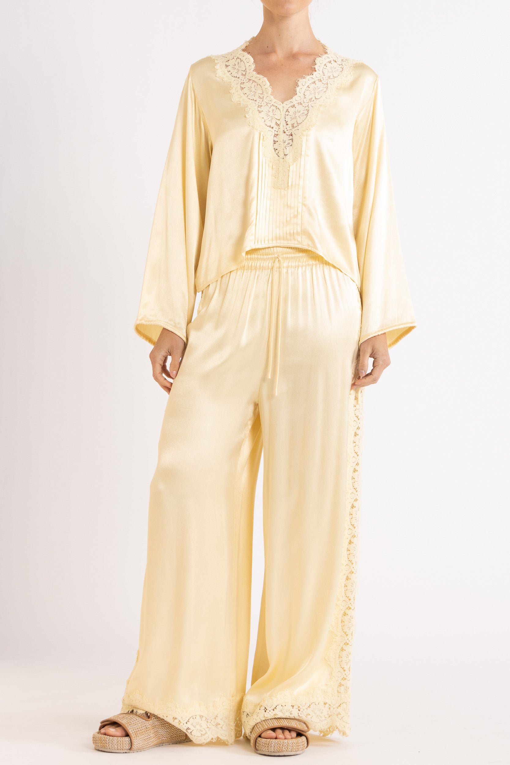 Woman wearing matching Vanilla lace-lined long sleeve top and pant on a white background