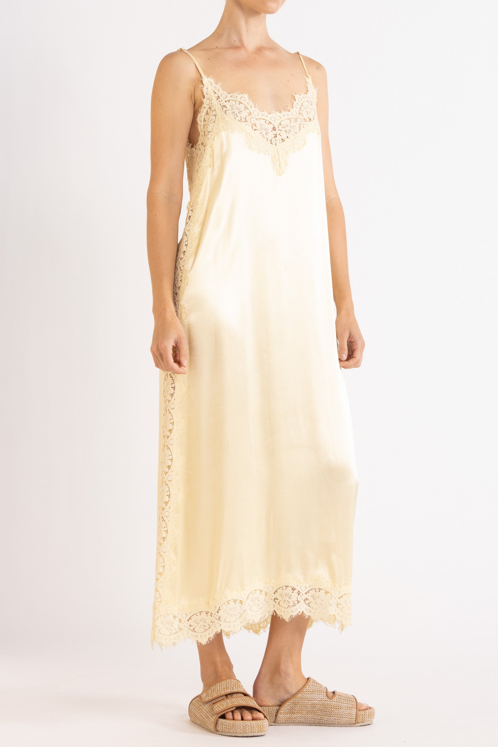 Woman wearing vanilla lace-trimmed camisole slip dress