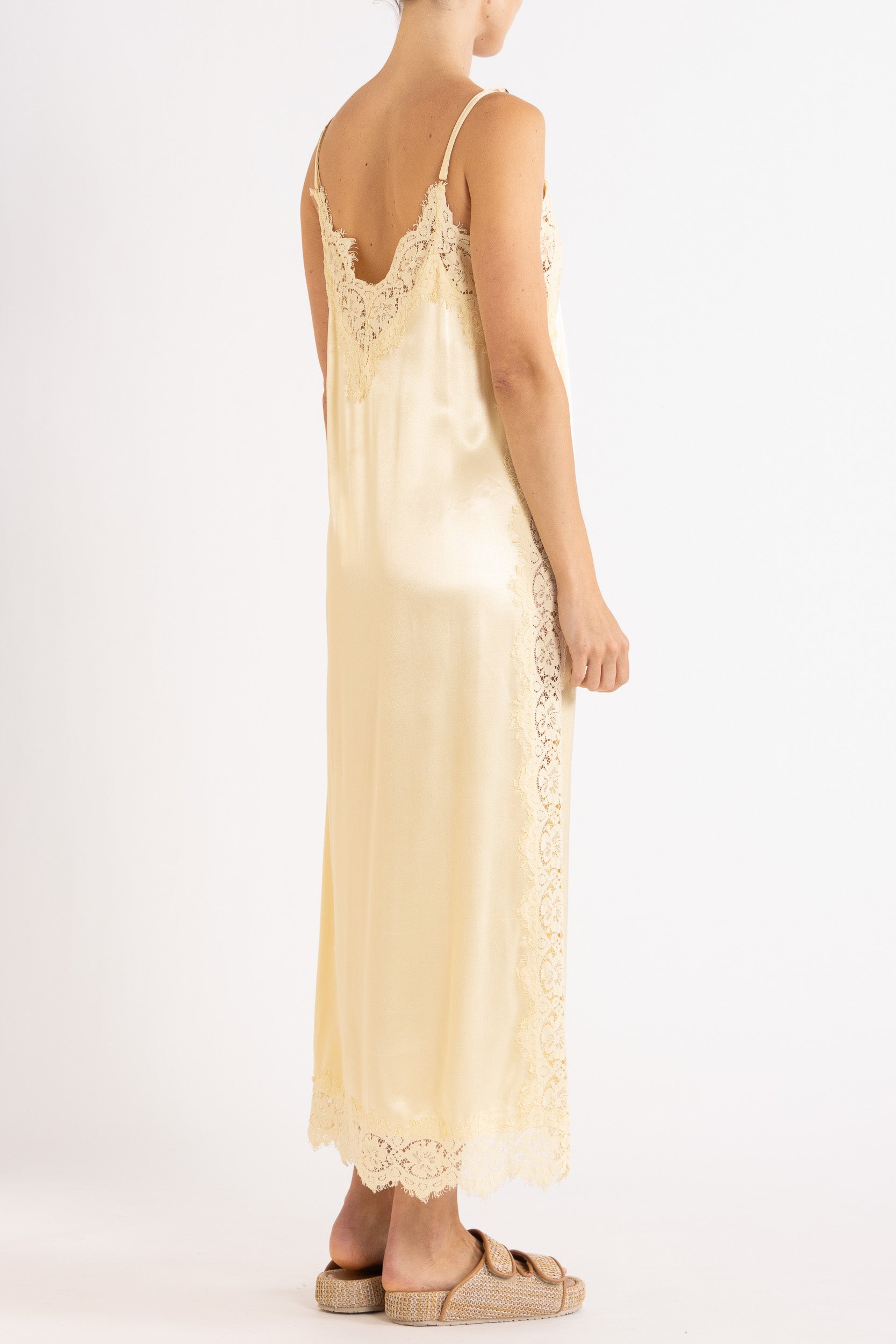 Woman wearing vanilla lace-trimmed camisole slip dress