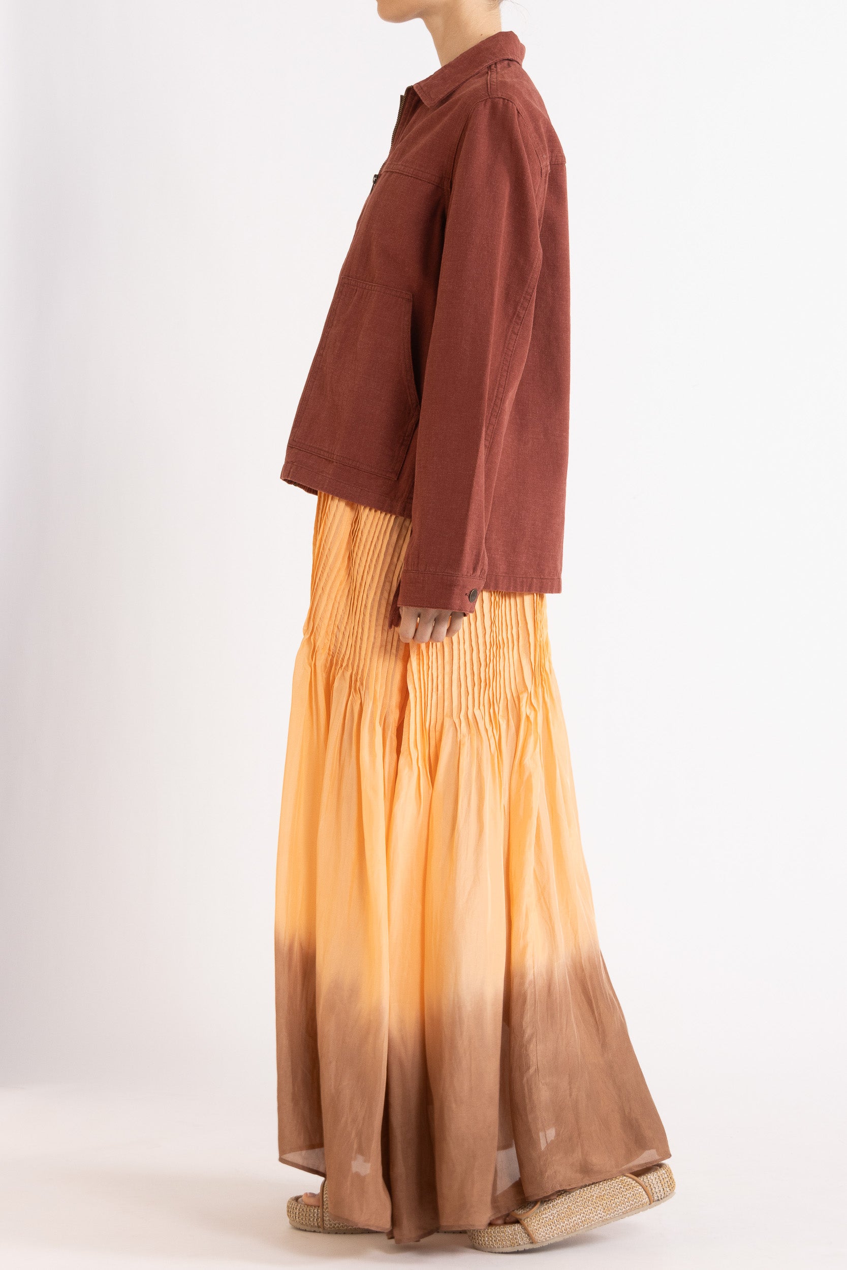 Model wearing burgundy cotton-twill utility jacket & peach dip-dye silk dress, side view