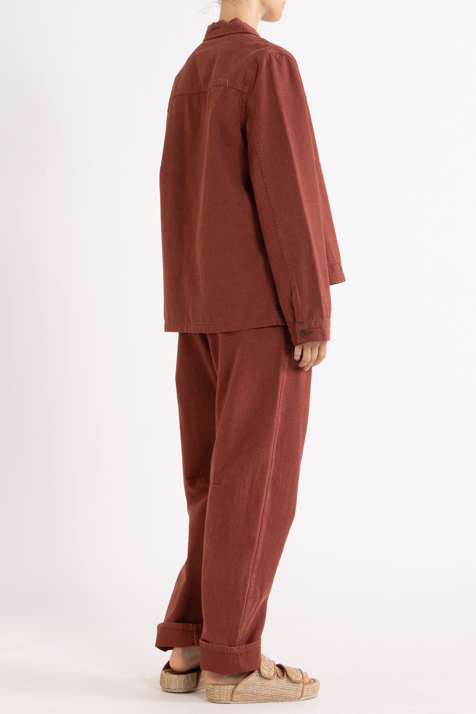 Model wearing burgundy cotton-twill utility jacket & pant, back-side view