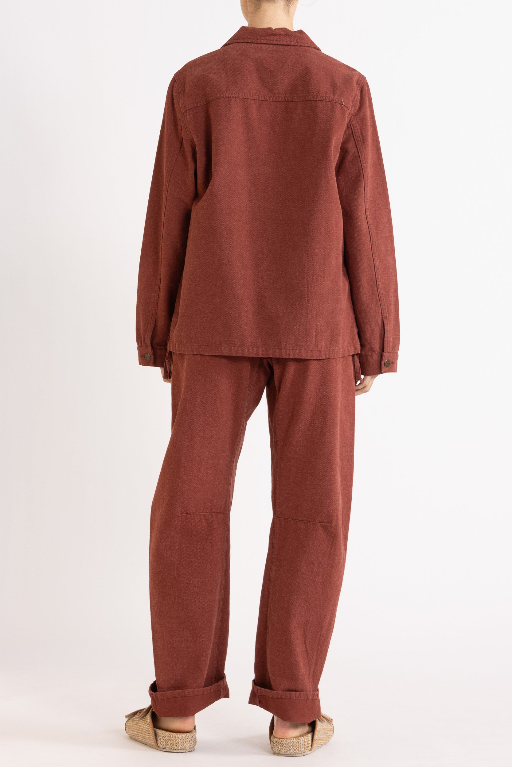Model wearing burgundy cotton-twill utility jacket & pant, back view