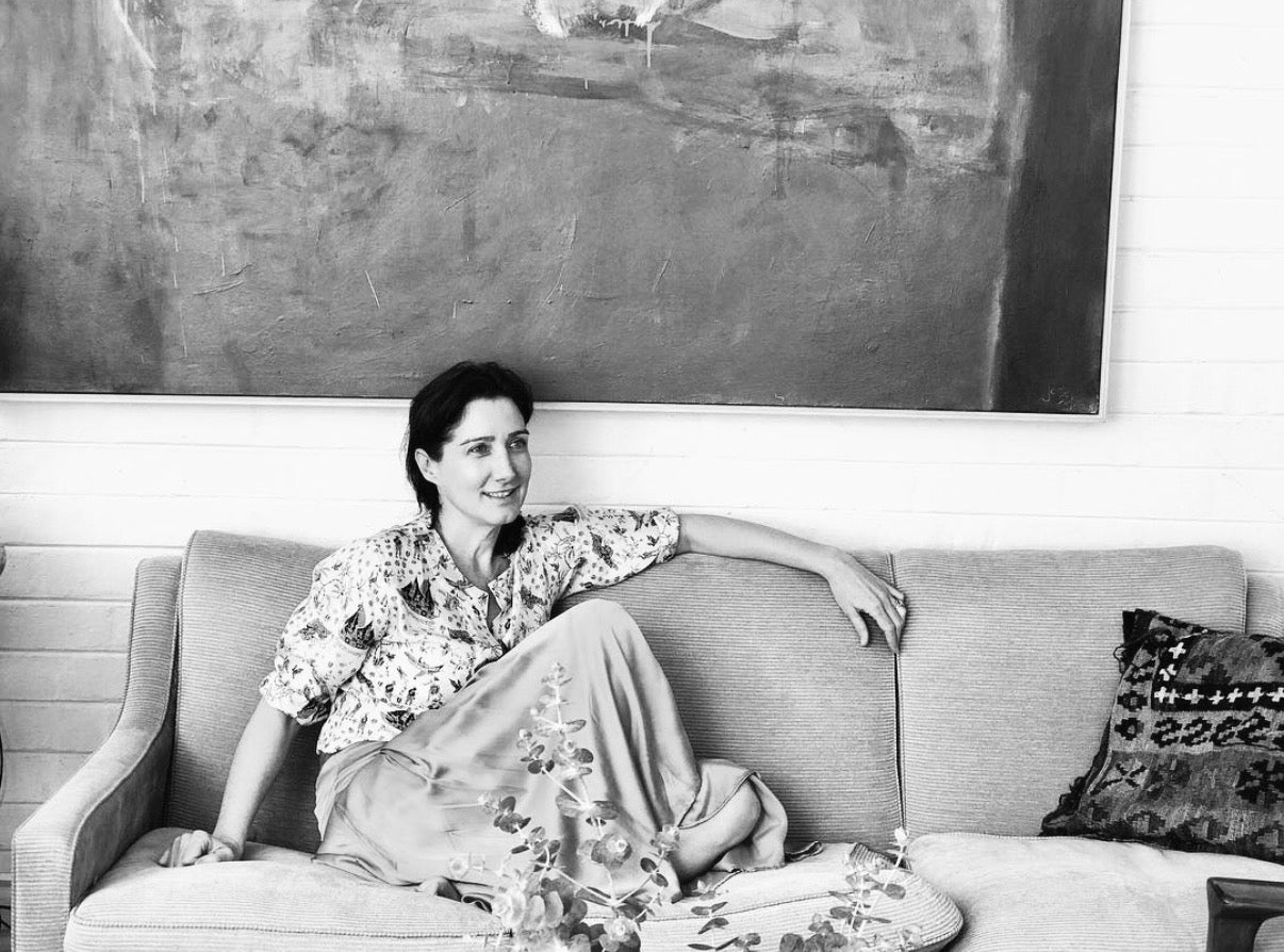 Image of FLANNEL creative director Kristy Lawrence sitting on a couch. 