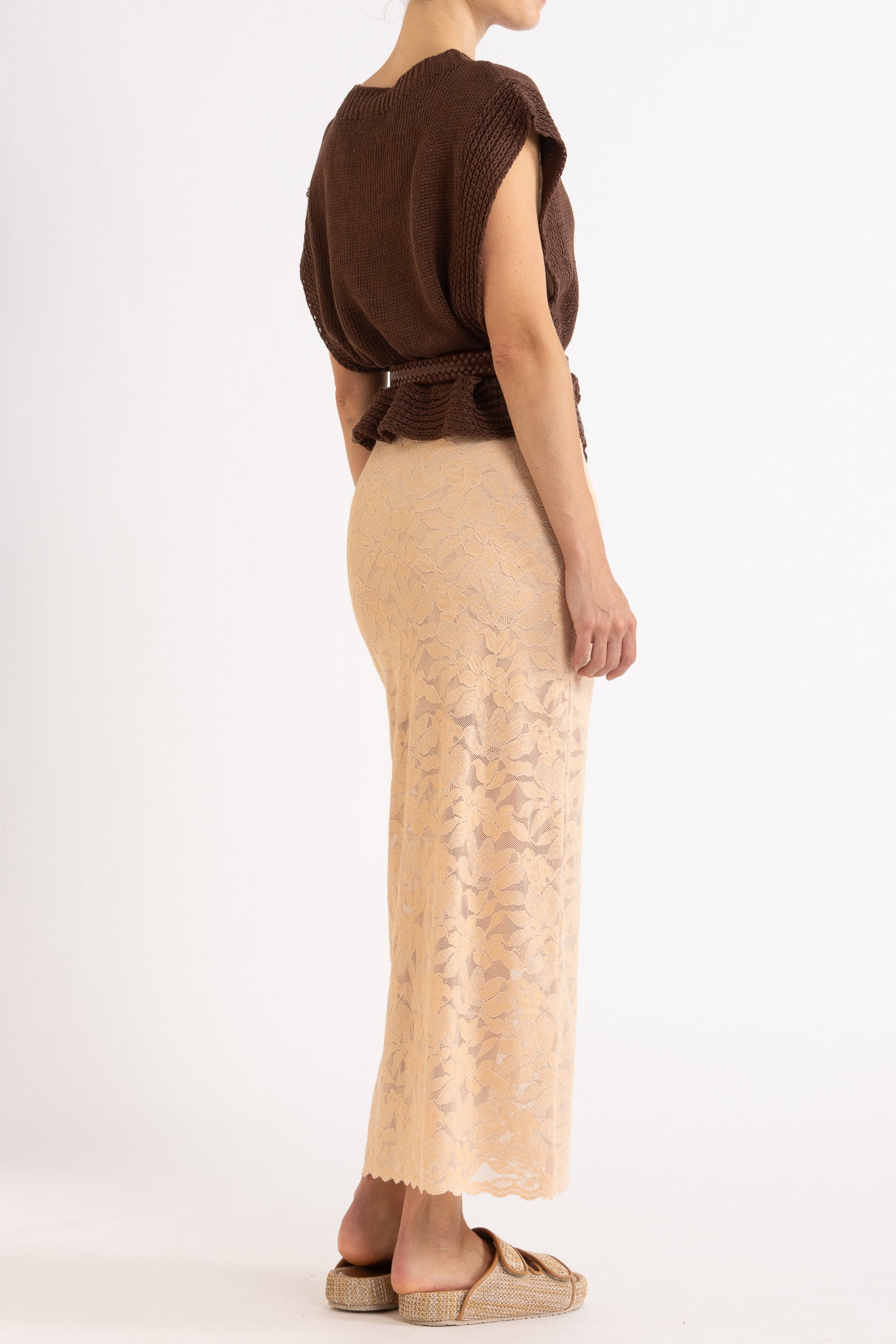 Woman wearing brown linen vest with a braided brown belt and biscuit lace skirt