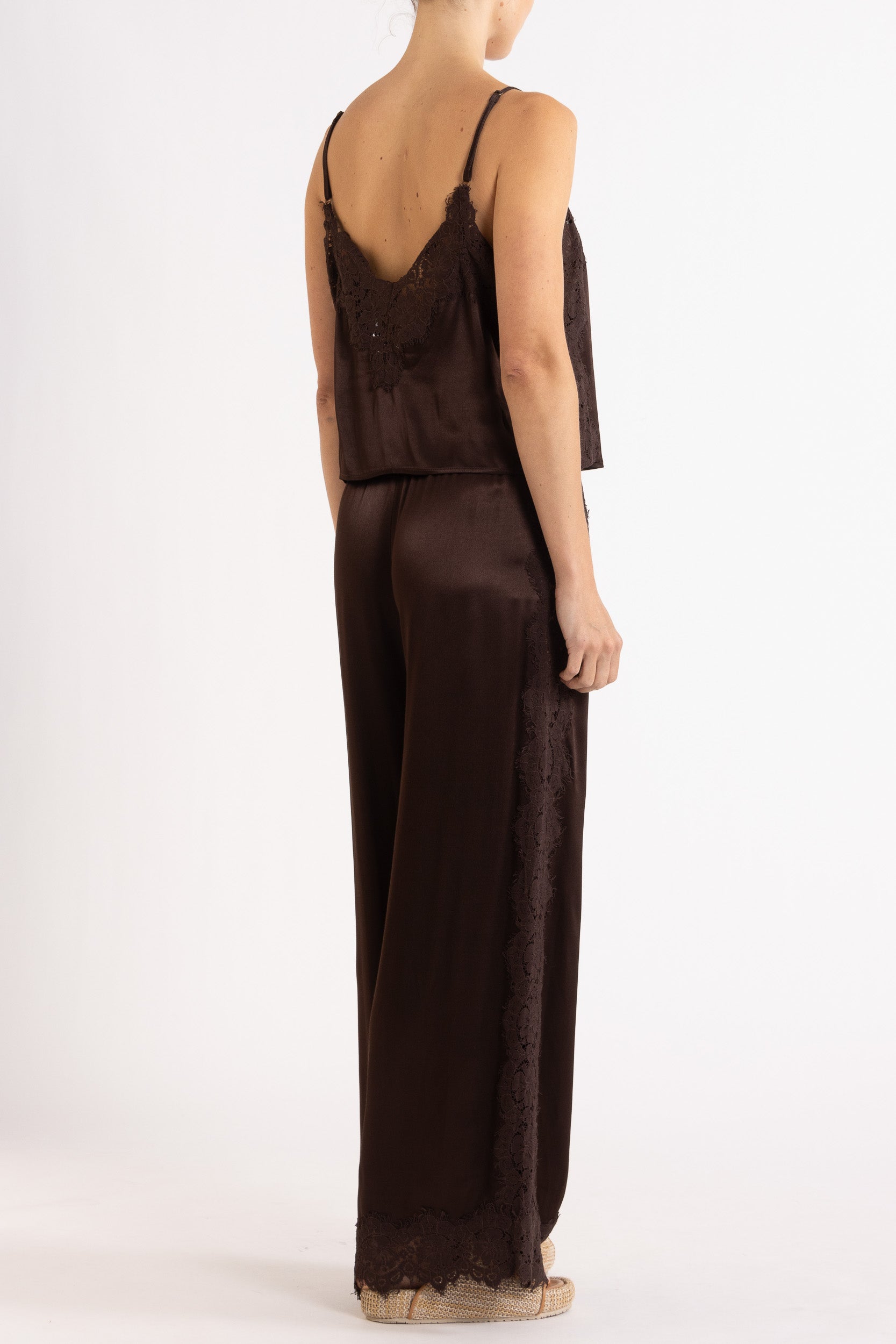 Woman wearing matching brown camisole and pant on a white background